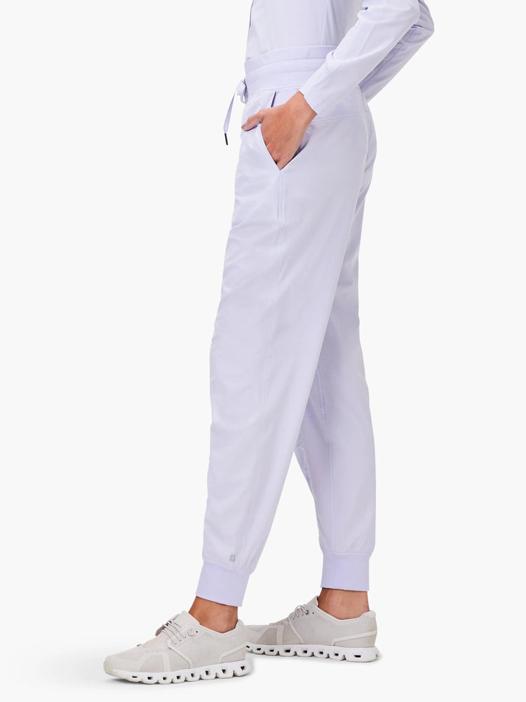 Light purple joggers with elastic waist, drawstring, side pockets, and elastic ankle cuffs.