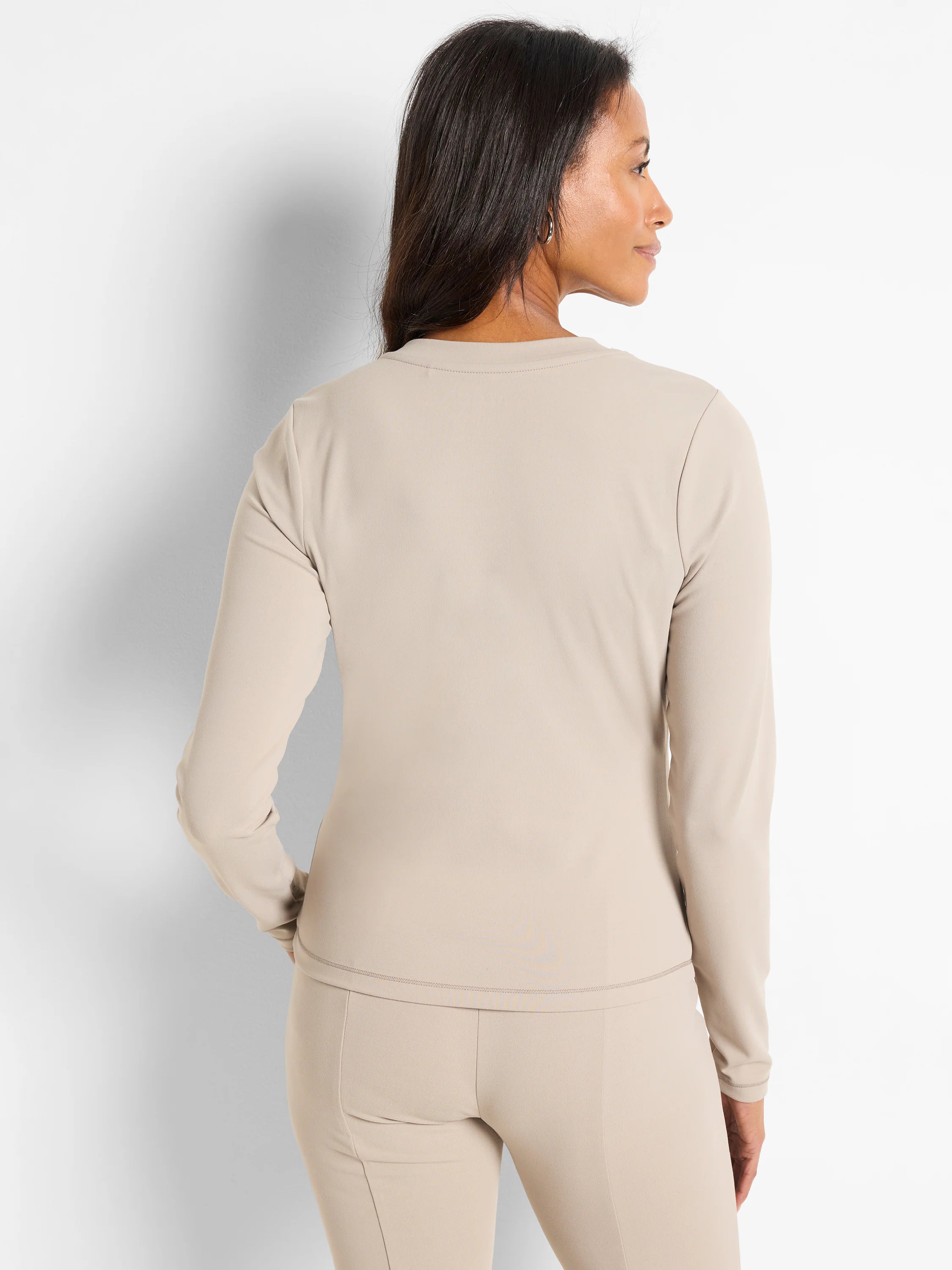 Beige long-sleeve top and leggings; subtle stitching detail.