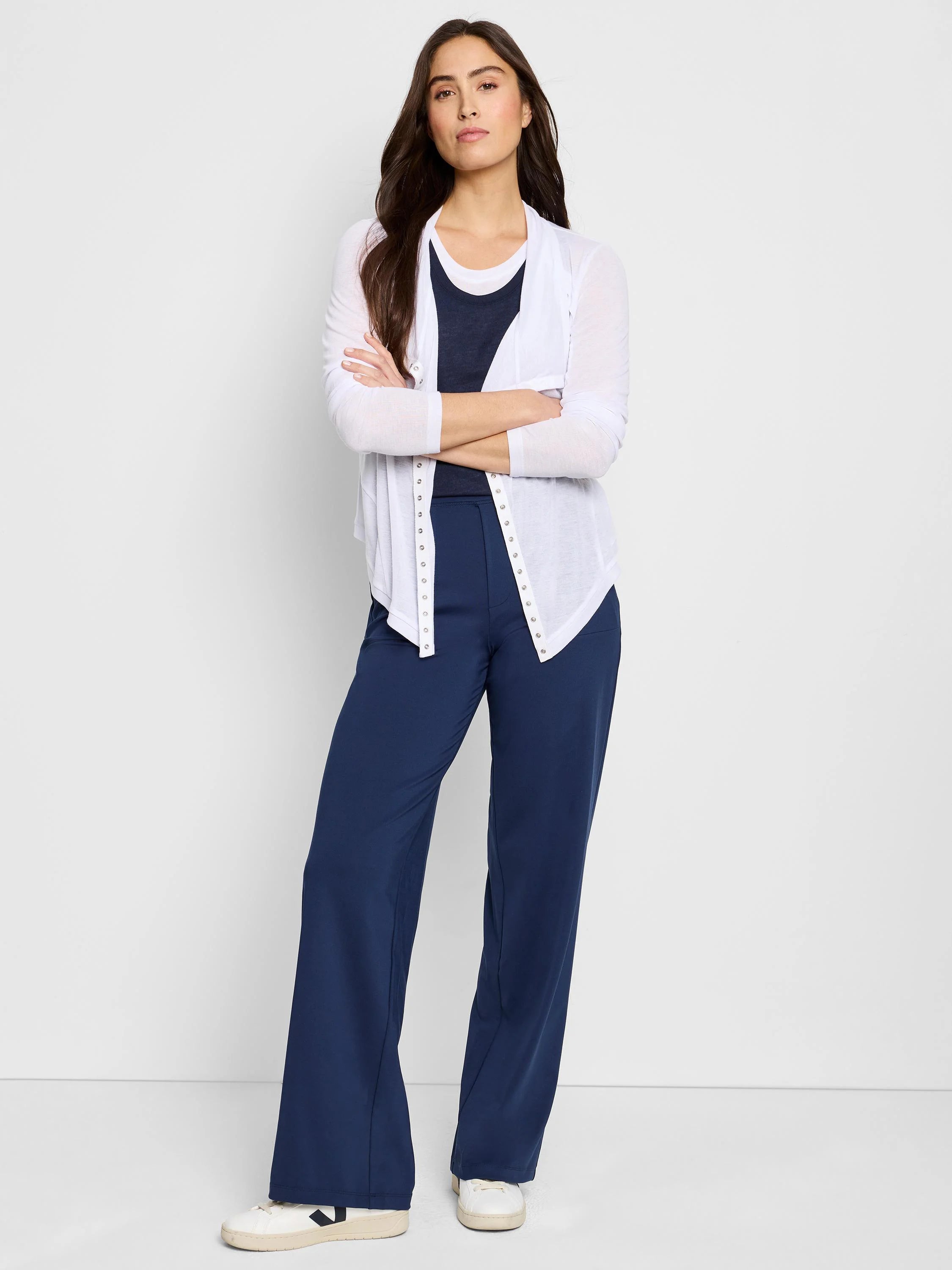 White gauzy cardigan with snap front closure, shown with navy pants. Long sleeves.