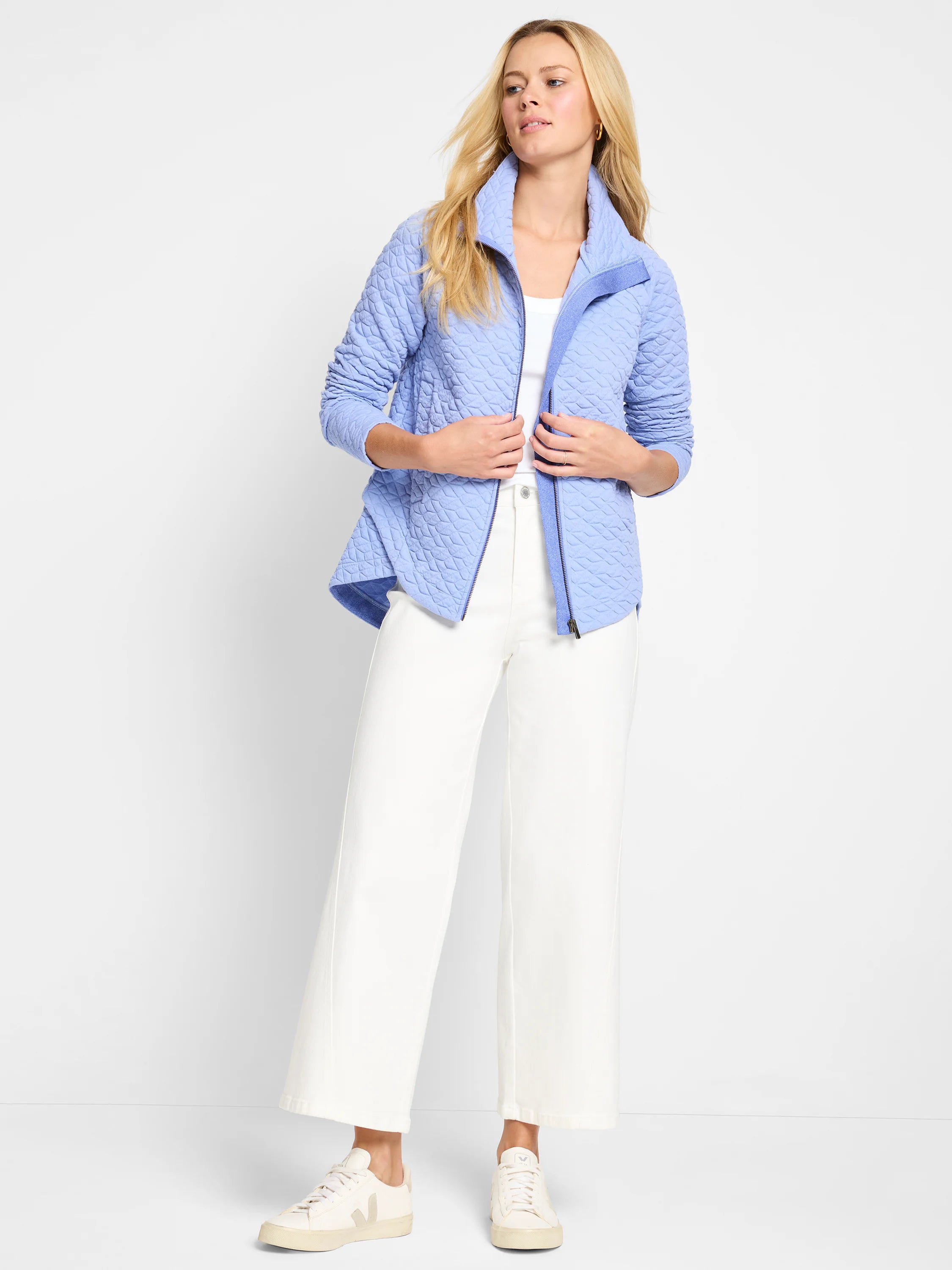 Light blue quilted jacket with a high collar and zipper. The quilting is a geometric pattern. Lining is visible in a...