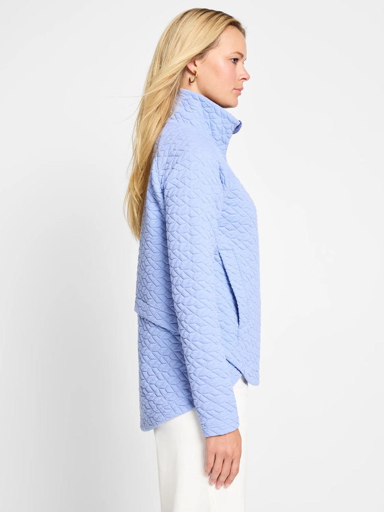 Light blue quilted jacket, half-zip closure. Textured fabric.