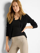 Black zip-front mesh cardigan.  Open-weave knit. Shown with a black top and beige pants.