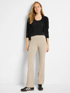 Black mesh zip-front cardigan over black top; beige pants.