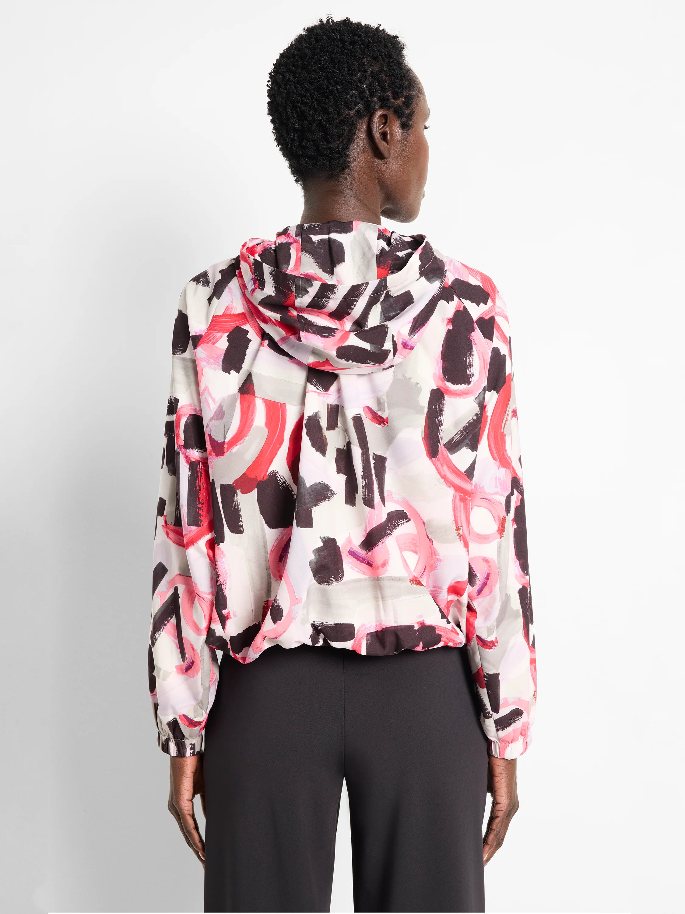 Hooded windbreaker with an abstract print. Colors: off-white base, dark gray, black brushstrokes, and bright pink/coral...