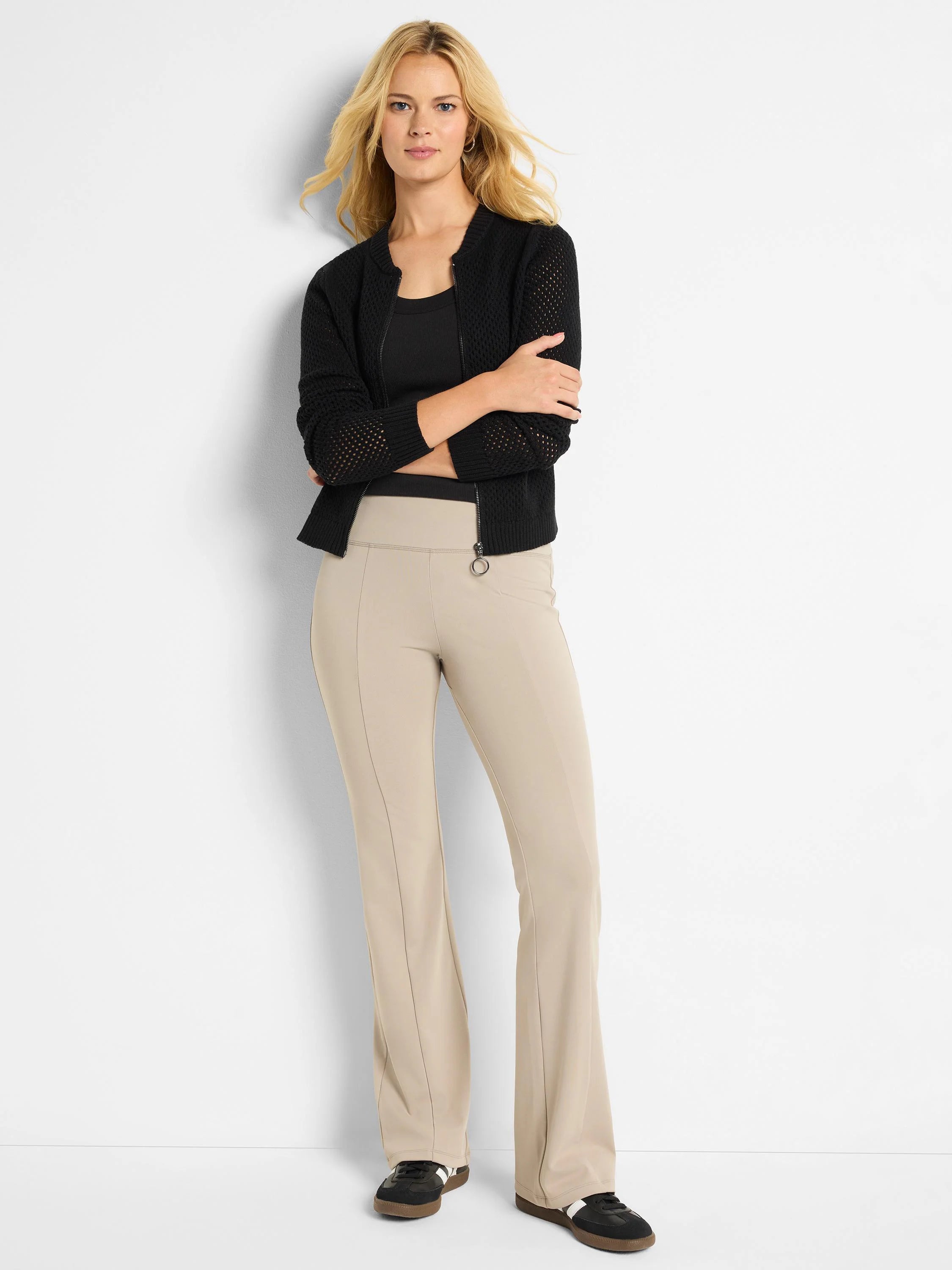 Beige bootcut pants; high-waisted, with center creases. Model also wears black cardigan & shoes.