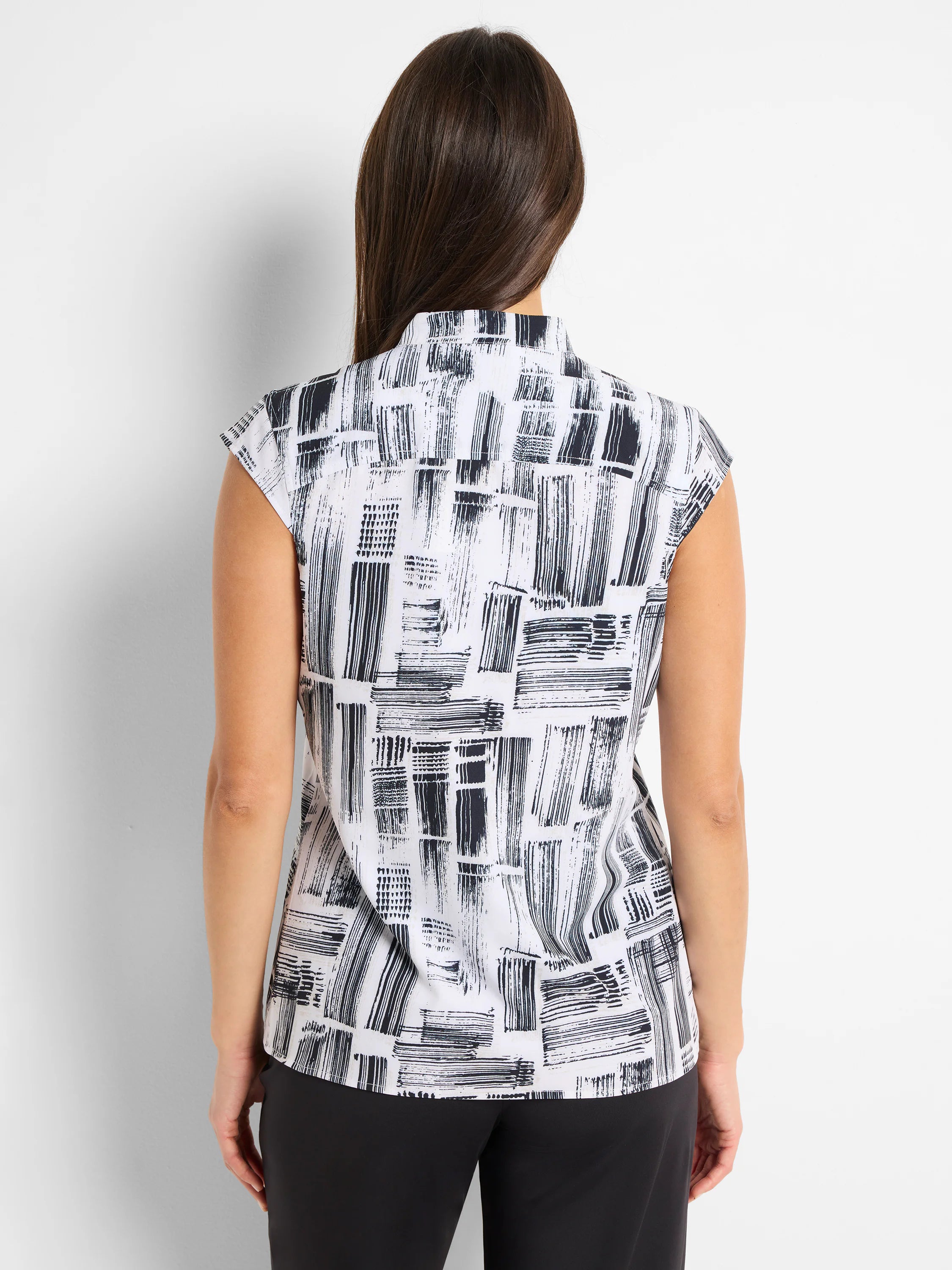 White sleeveless snap-neck top with black brushstroke pattern.