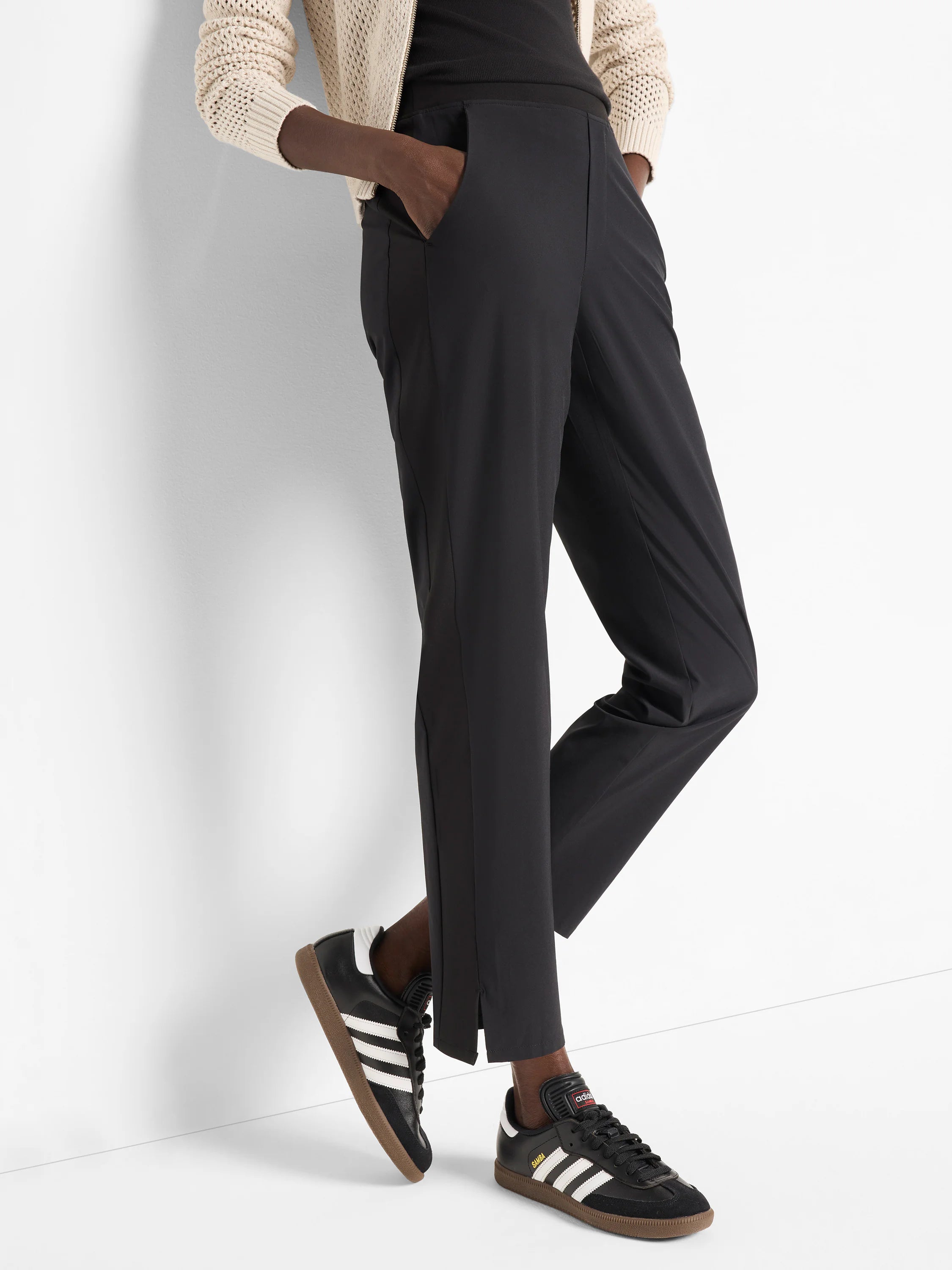 Black ankle-length pants with side slits, shown on a model.