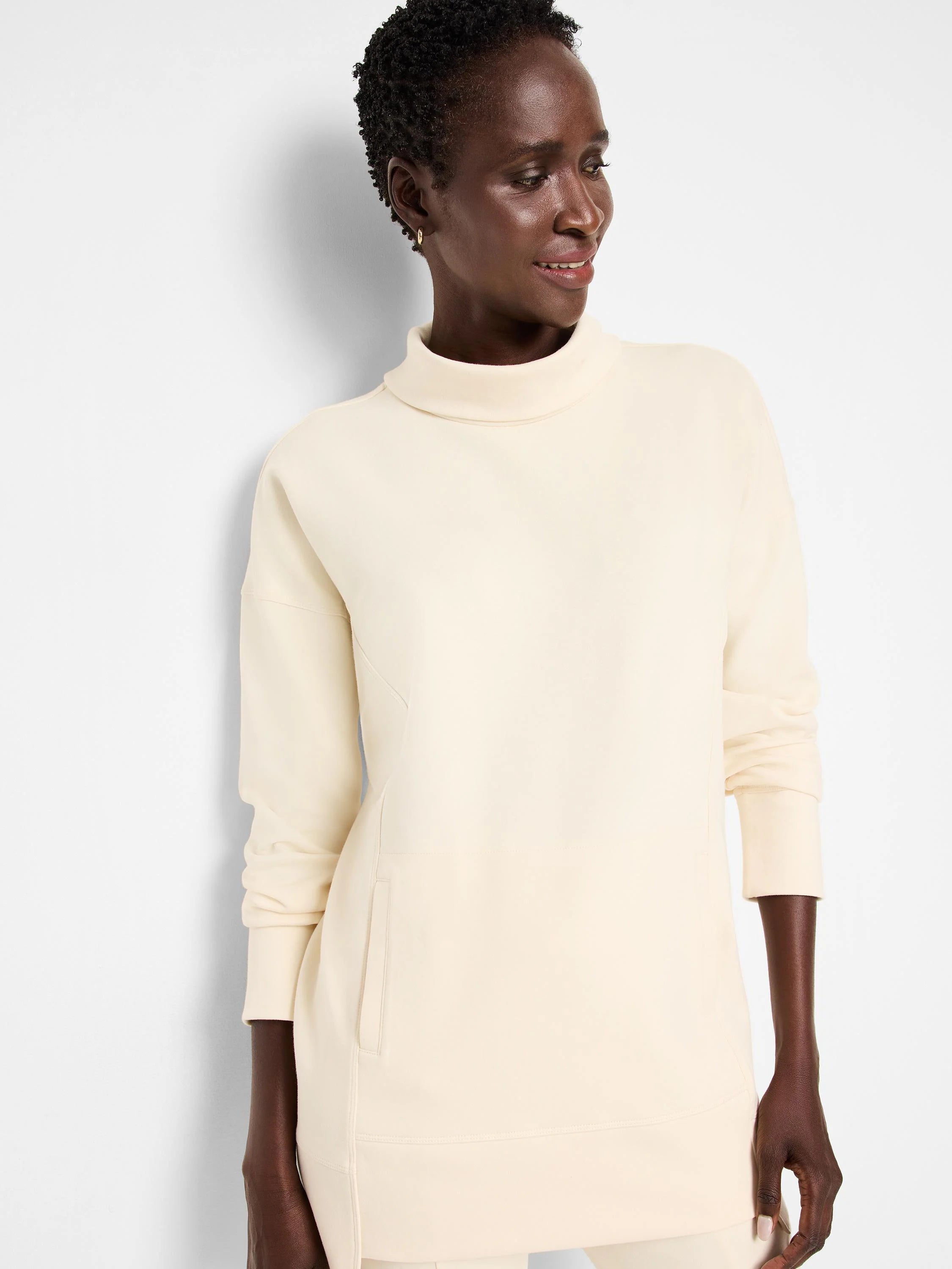 Off-white tunic with funnel neck, long sleeves, and a side pocket. Seams are visible.