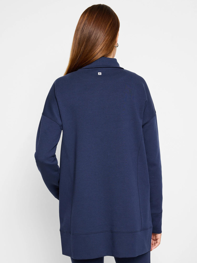 Navy blue tunic, long sleeves, funnel neck, seamed detail at sides. Small logo on back.