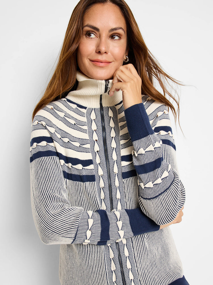 Fairisle zip-front cardigan in cream and navy blue. Features horizontal stripes and a textured pattern. High neck and...