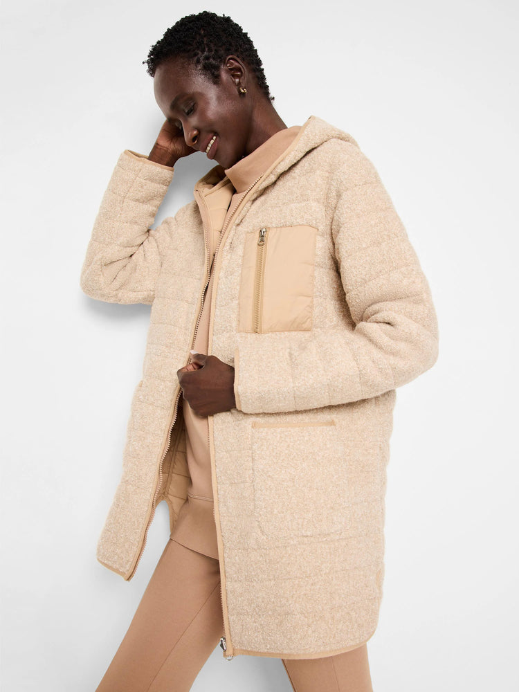 Beige hooded coat, quilted, reversible. Features a lighter beige inner lining and zip closure.