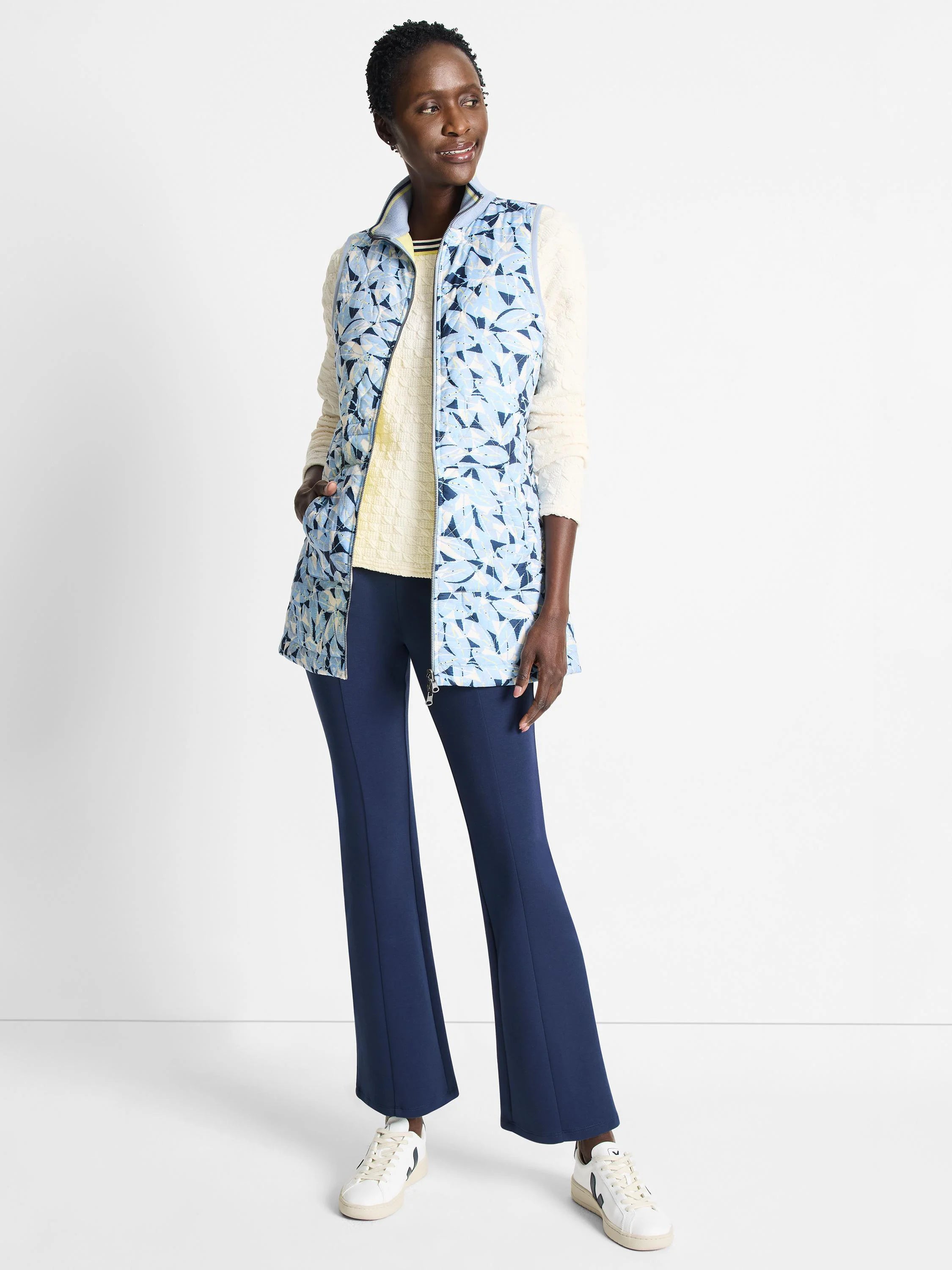 Reversible vest; light blue with darker blue floral pattern on one side. Zip front.