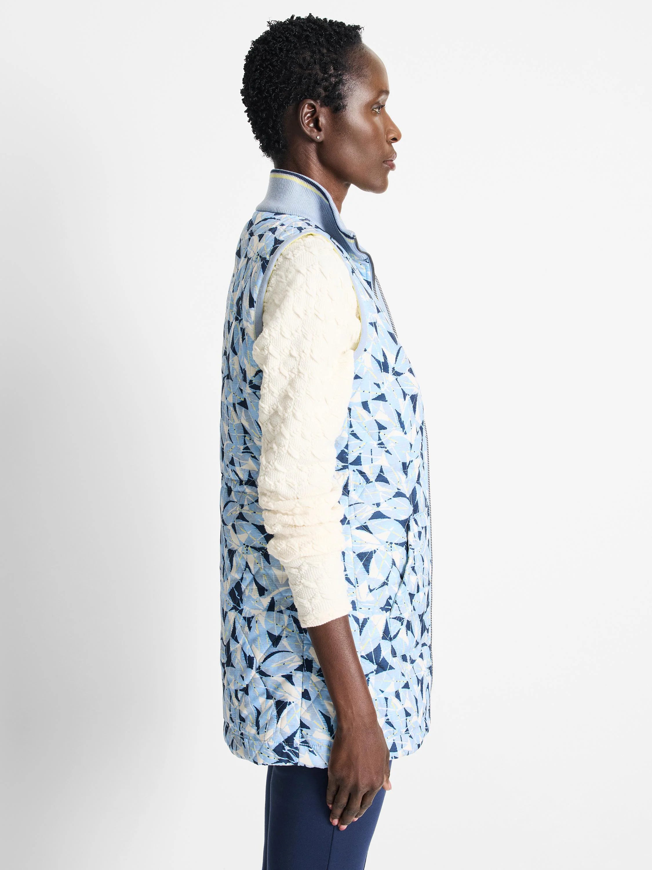 Reversible vest; light blue with dark blue floral pattern on one side. The other side is not shown. Quilted. Zipper front.