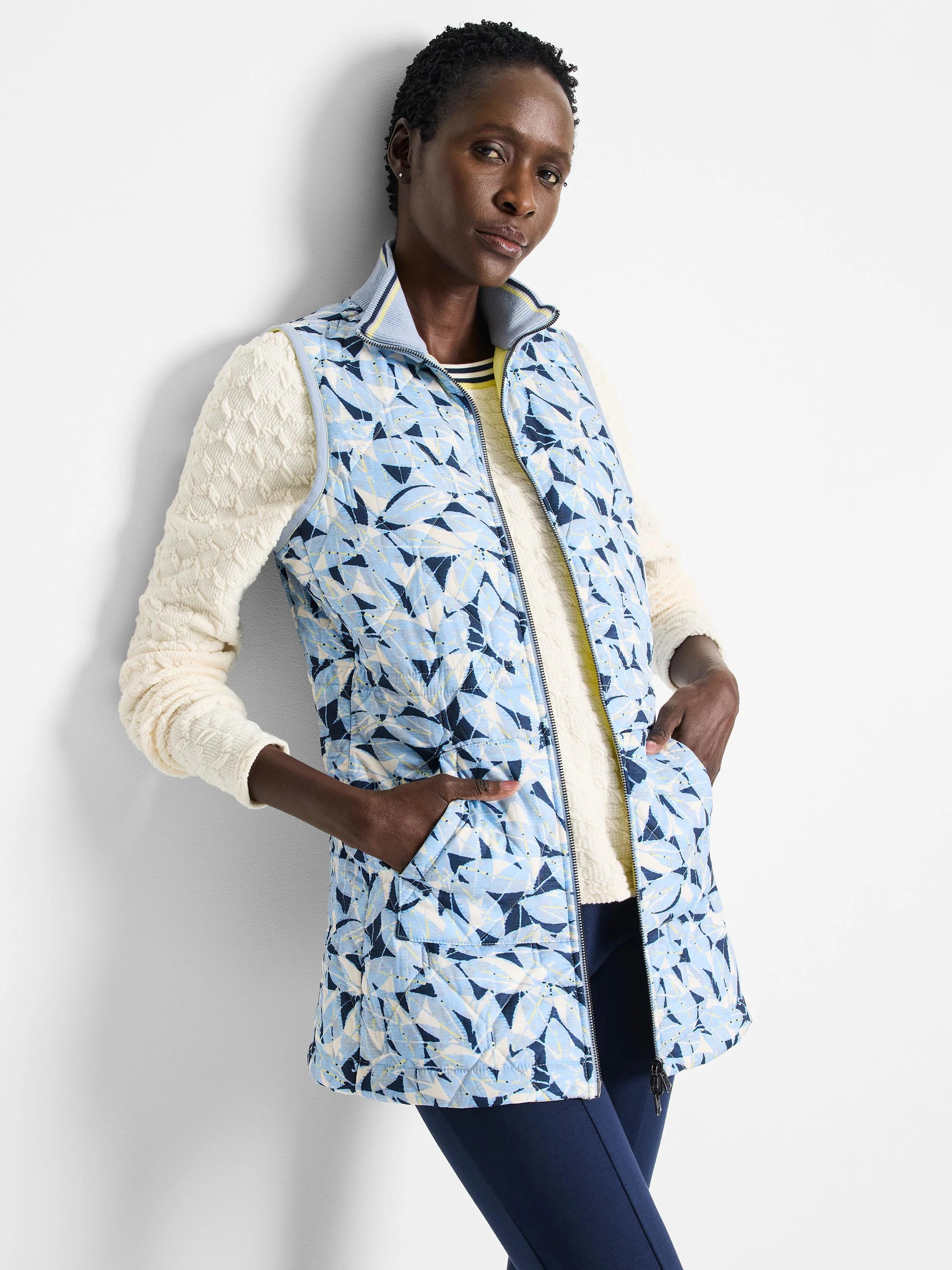 Reversible vest. One side: light blue quilted floral print with navy accents. Other side not shown.