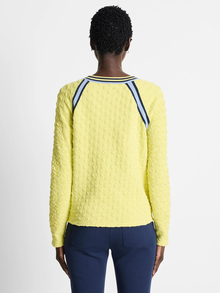 Pale yellow textured pullover sweater with navy and light blue shoulder stripes. Long sleeves.