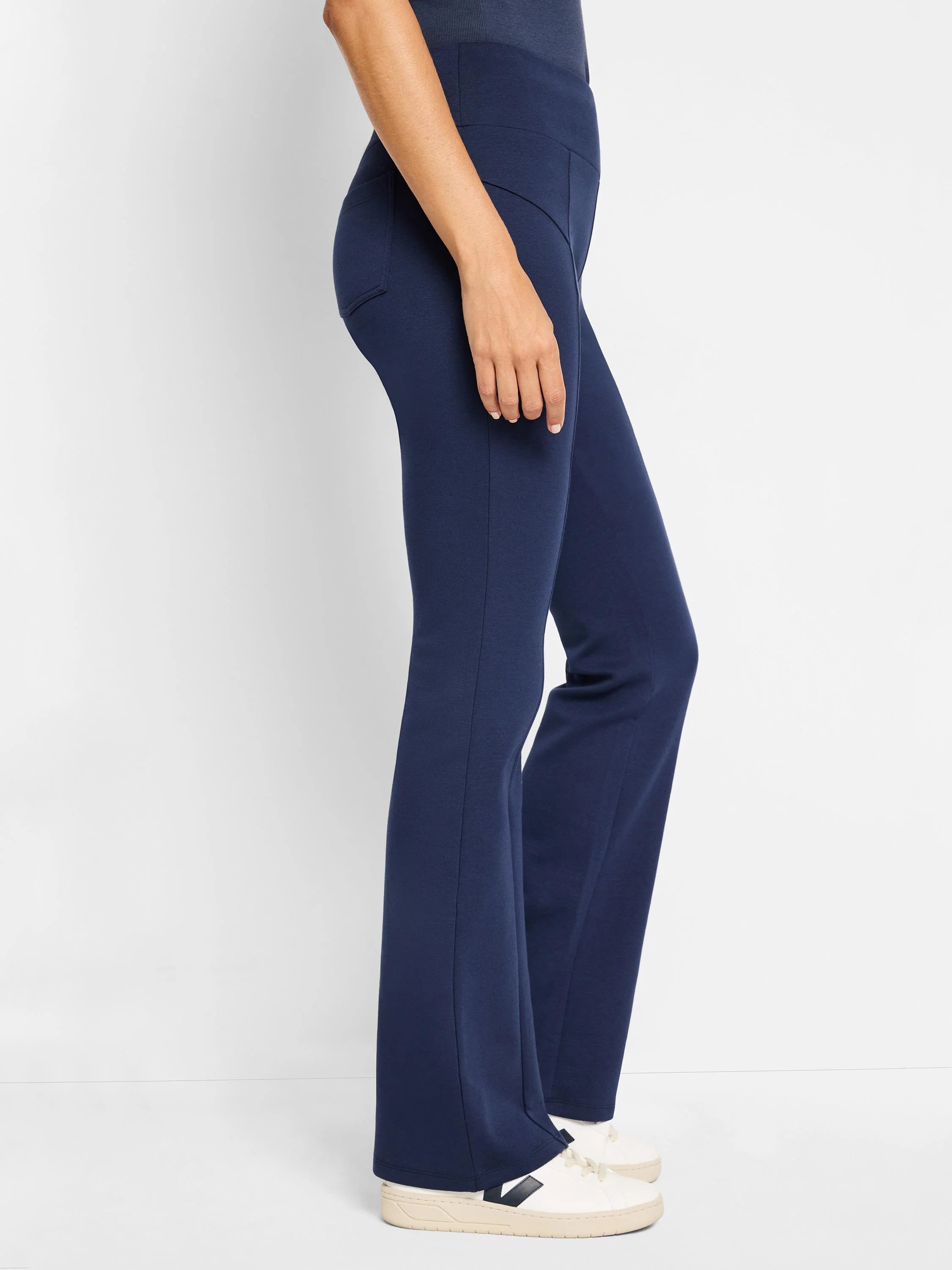 Dark navy blue bootcut pants. Seamed detail at the waist and legs. Shown on a model.