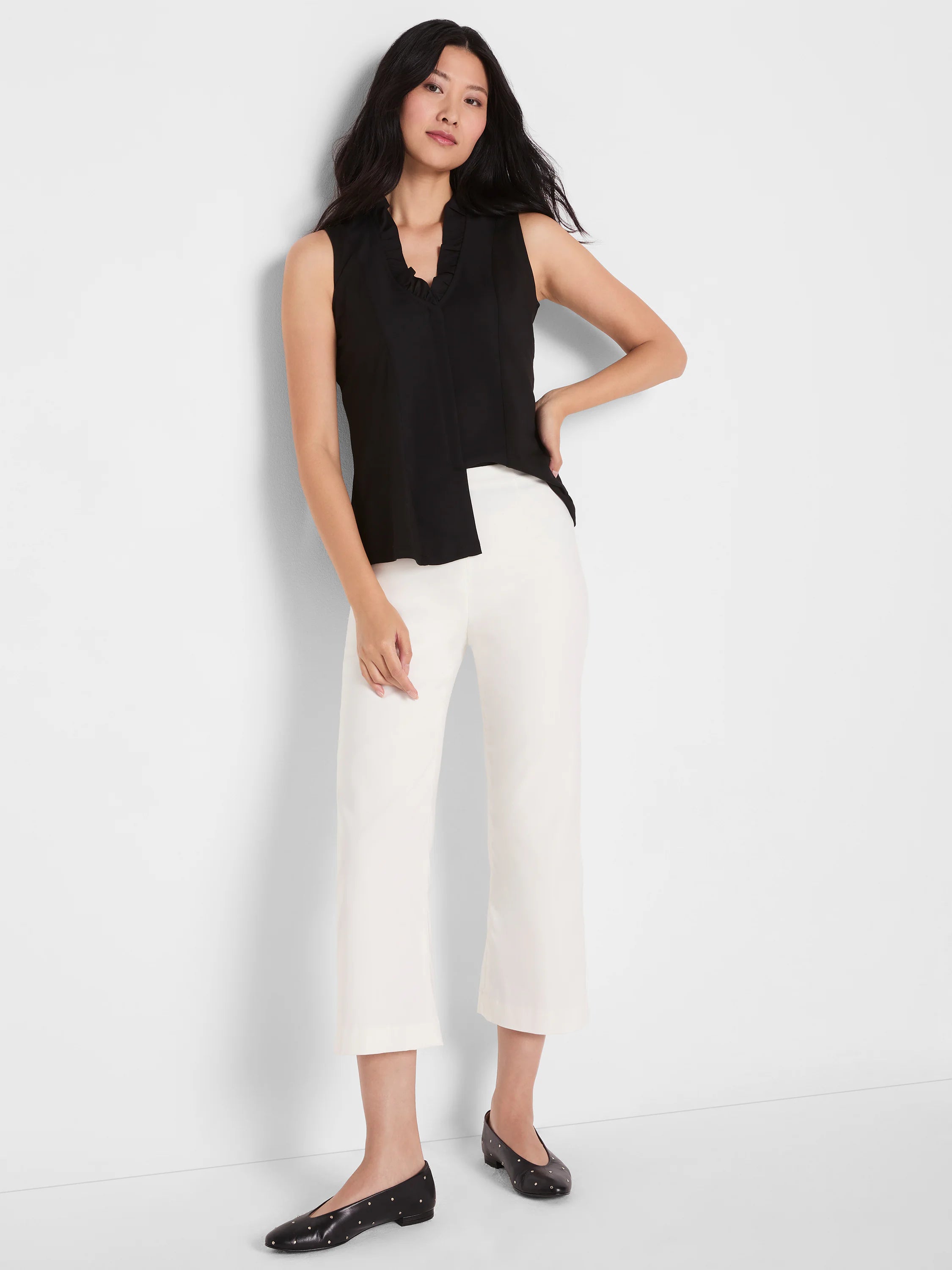 Black tank with ruffled V-neck and asymmetrical split front hem.