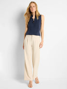 Navy sleeveless tank top with a ruffled high V-neck and a single button accent.