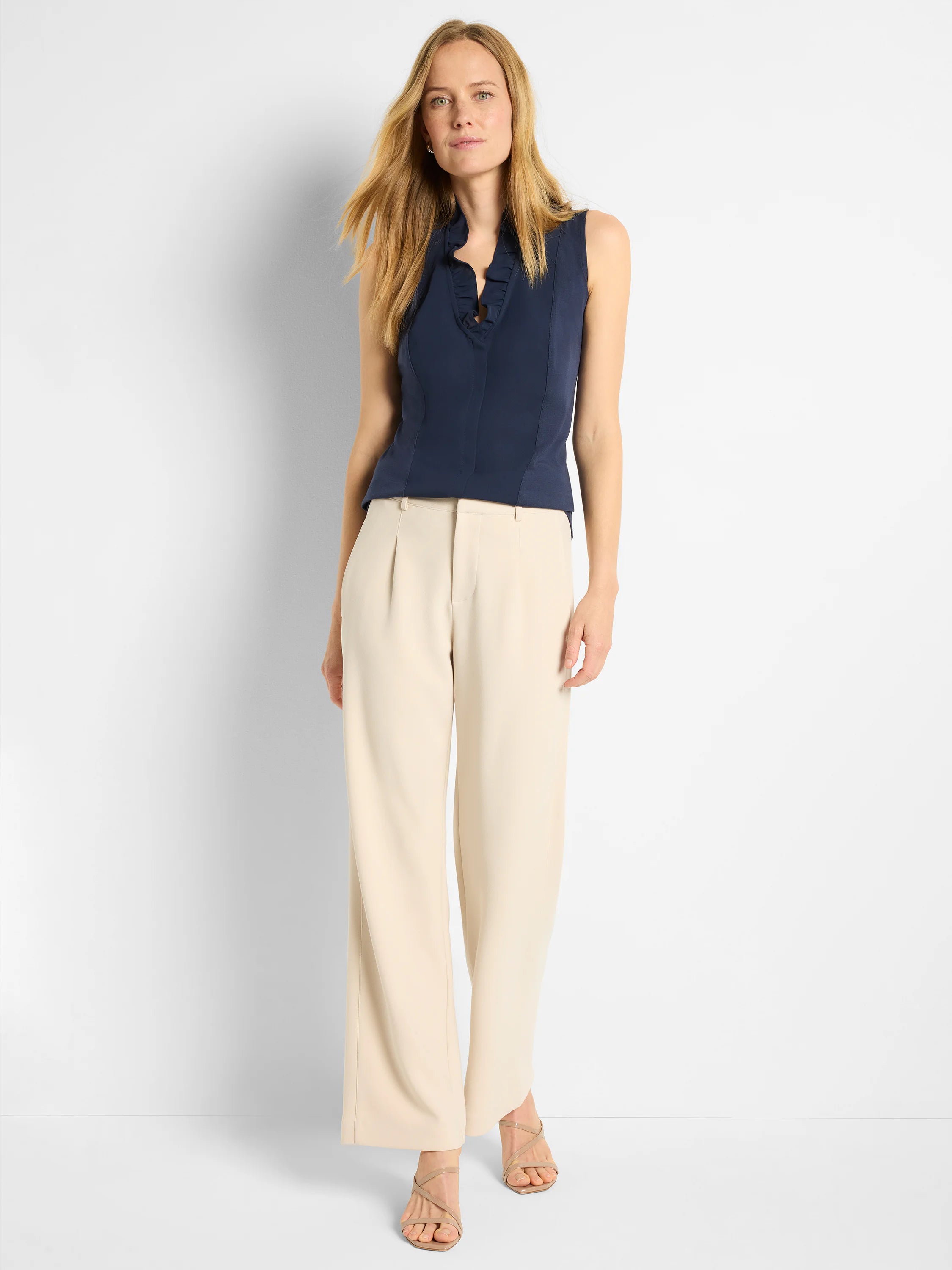 Navy sleeveless tank top with a ruffled high V-neck and a single button accent.