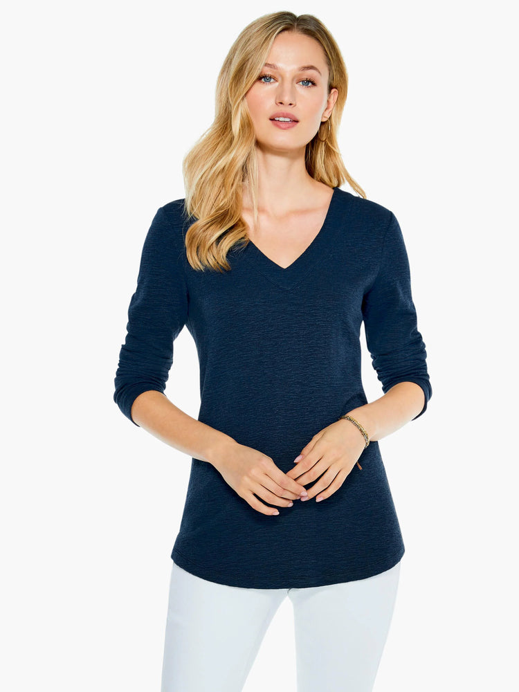 Dark navy blue, textured V-neck long-sleeve top. Slightly curved hem.