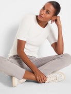 Off-white ribbed knit boatneck tee with elbow-length sleeves, worn by a model.