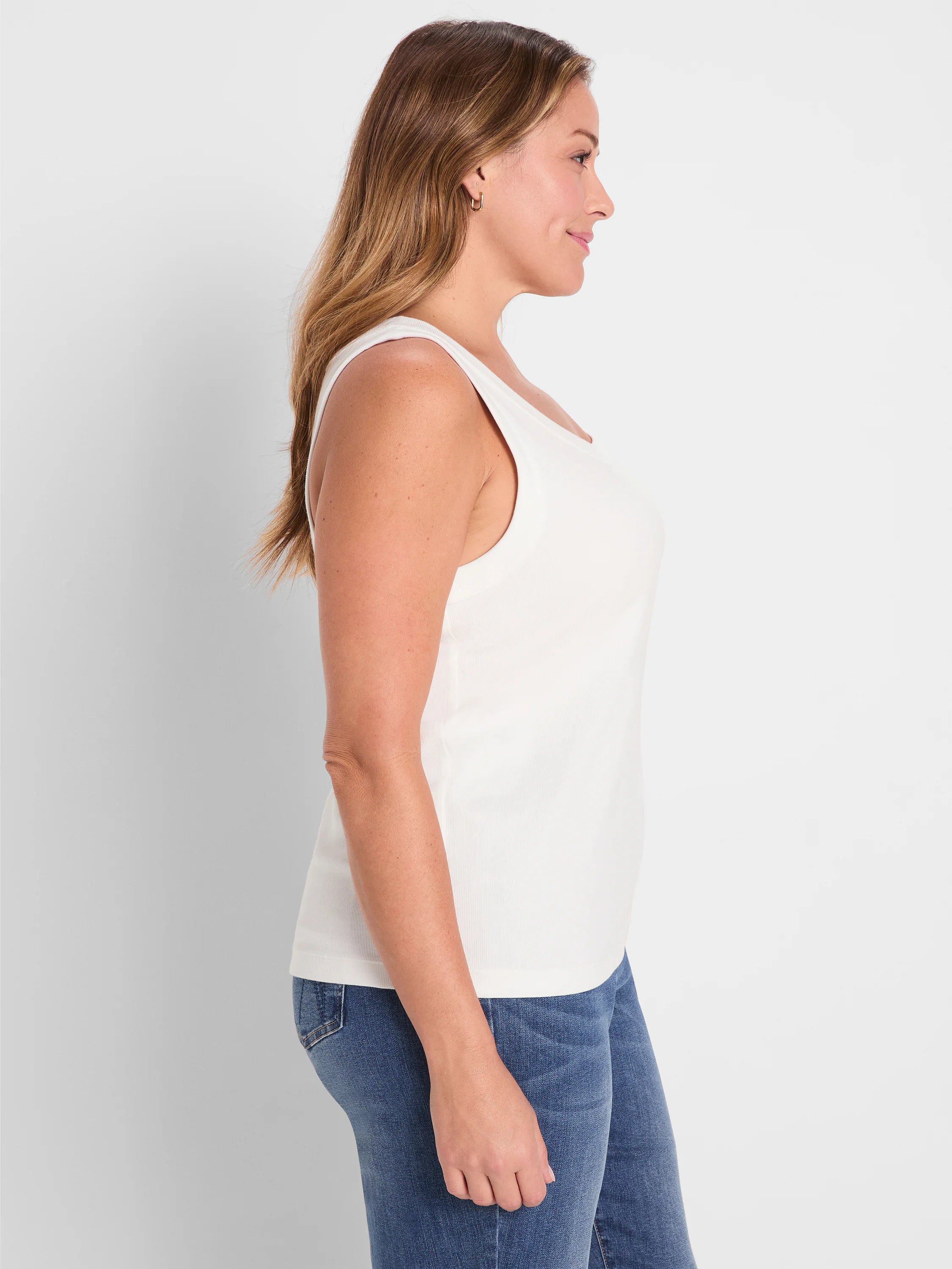 White ribbed knit scoop tank on a woman, shown in profile.