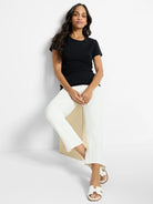 Black crew neck T-shirt with short sleeves, worn by a woman. It features a smooth knit texture and standard fit.