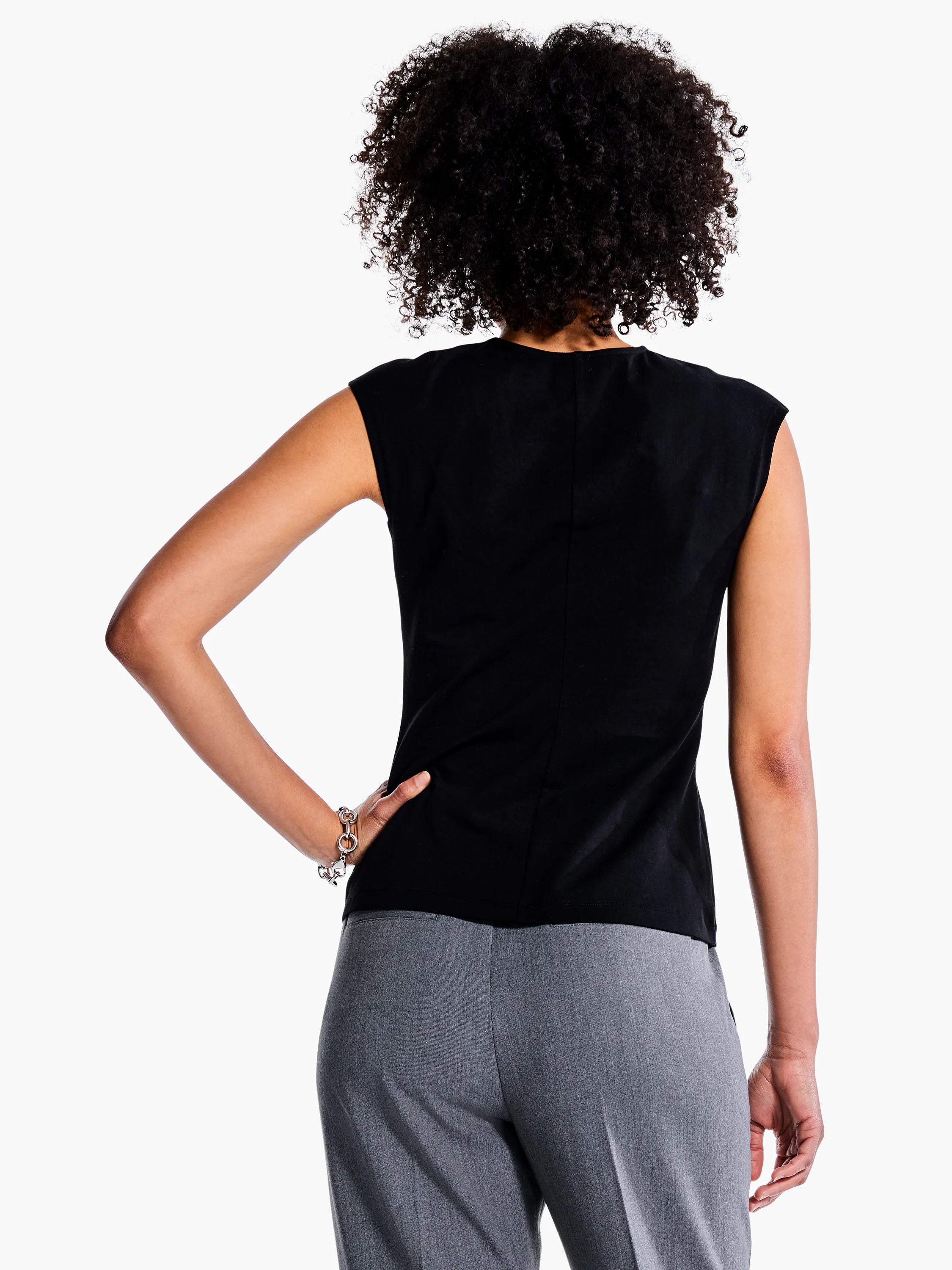 Black v-neck sleeveless top, shown from the back. Model also wears gray pants.