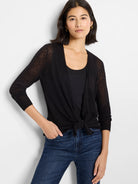 Black sheer cardigan, tied at the waist, with 3/4 sleeves and ribbed cuffs on a model.