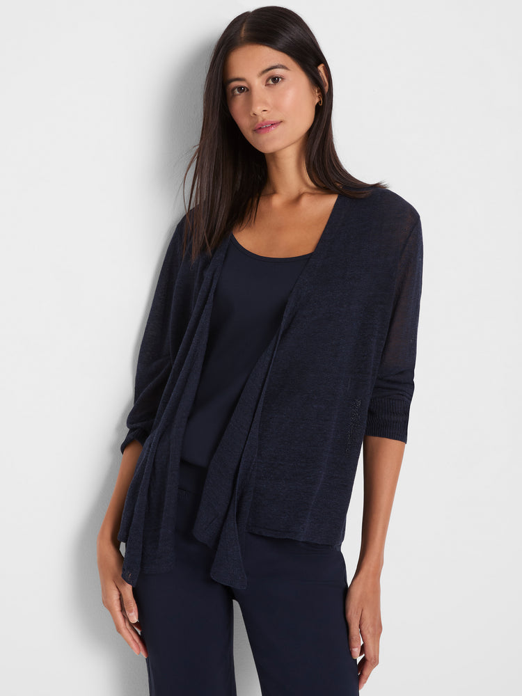 The model wears a sheer navy knit cardigan with three-quarter sleeves and a relaxed, draped open front.