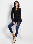 Black knit blazer with lapels, three gold front buttons, and four gold-buttoned flap pockets.