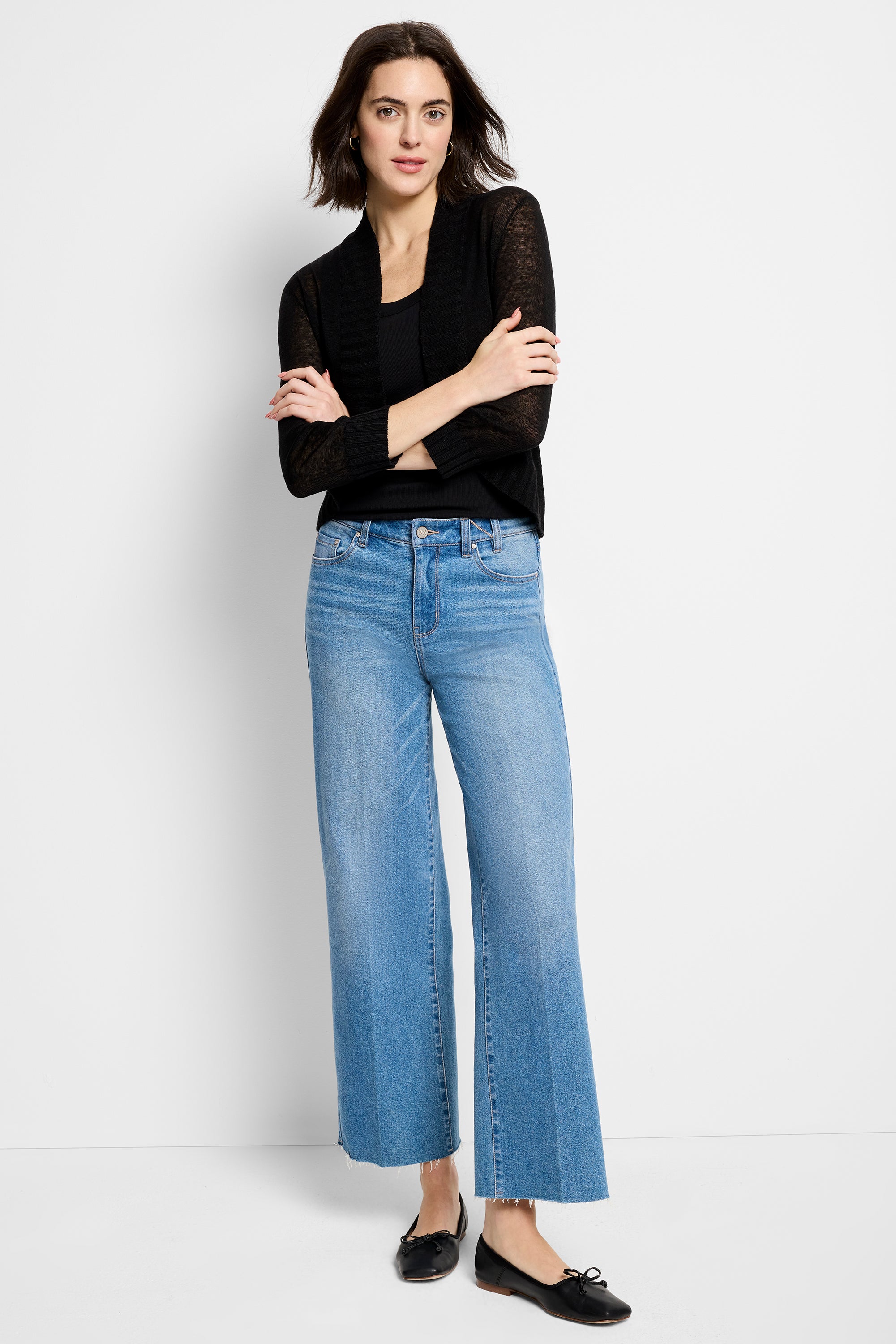 Lightweight, sheer black knit shrug with long sleeves and an open front, worn over a cami and cropped wide-leg jeans.