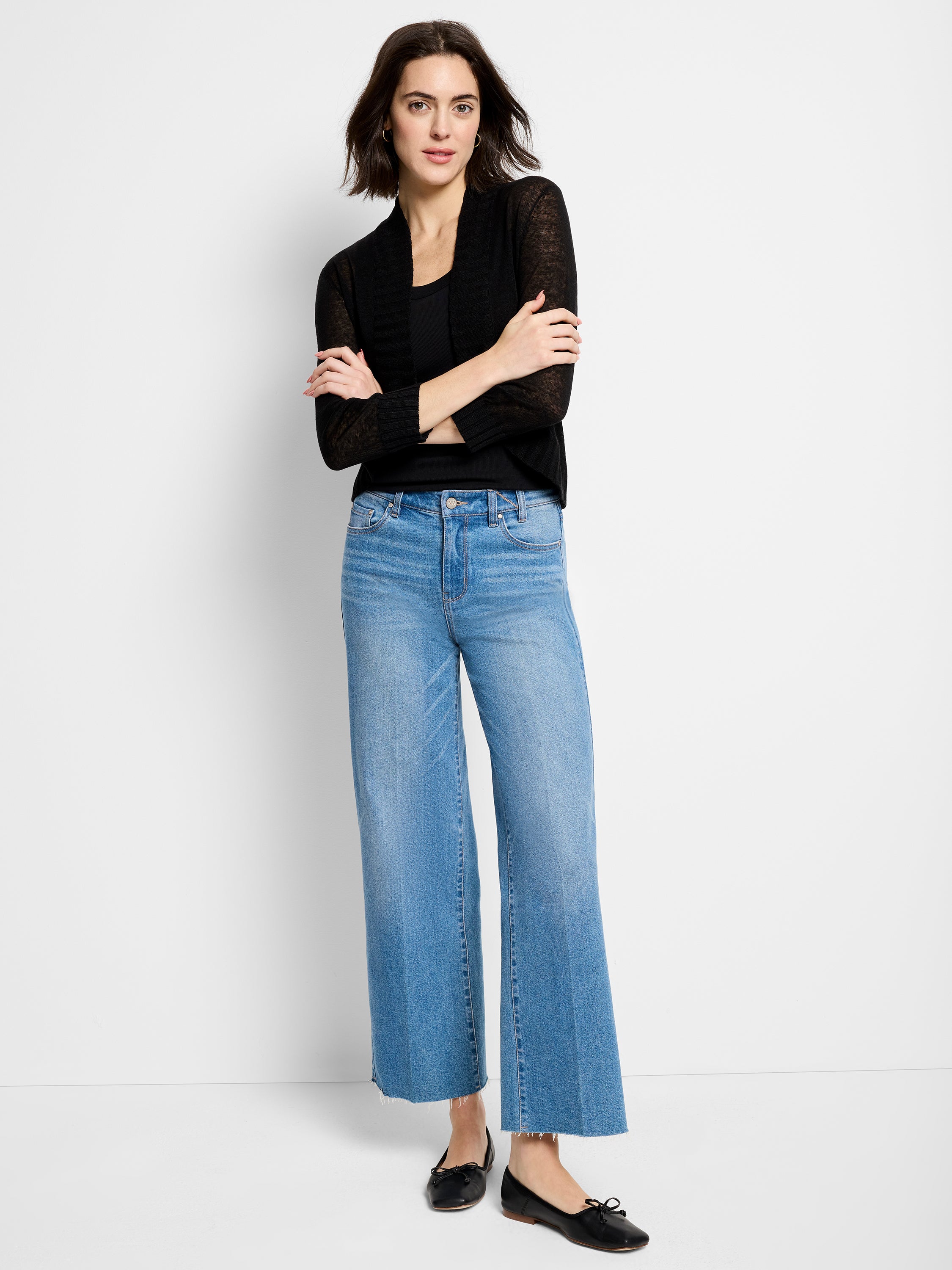 Lightweight, sheer black knit shrug with long sleeves and an open front, worn over a cami and cropped wide-leg jeans.