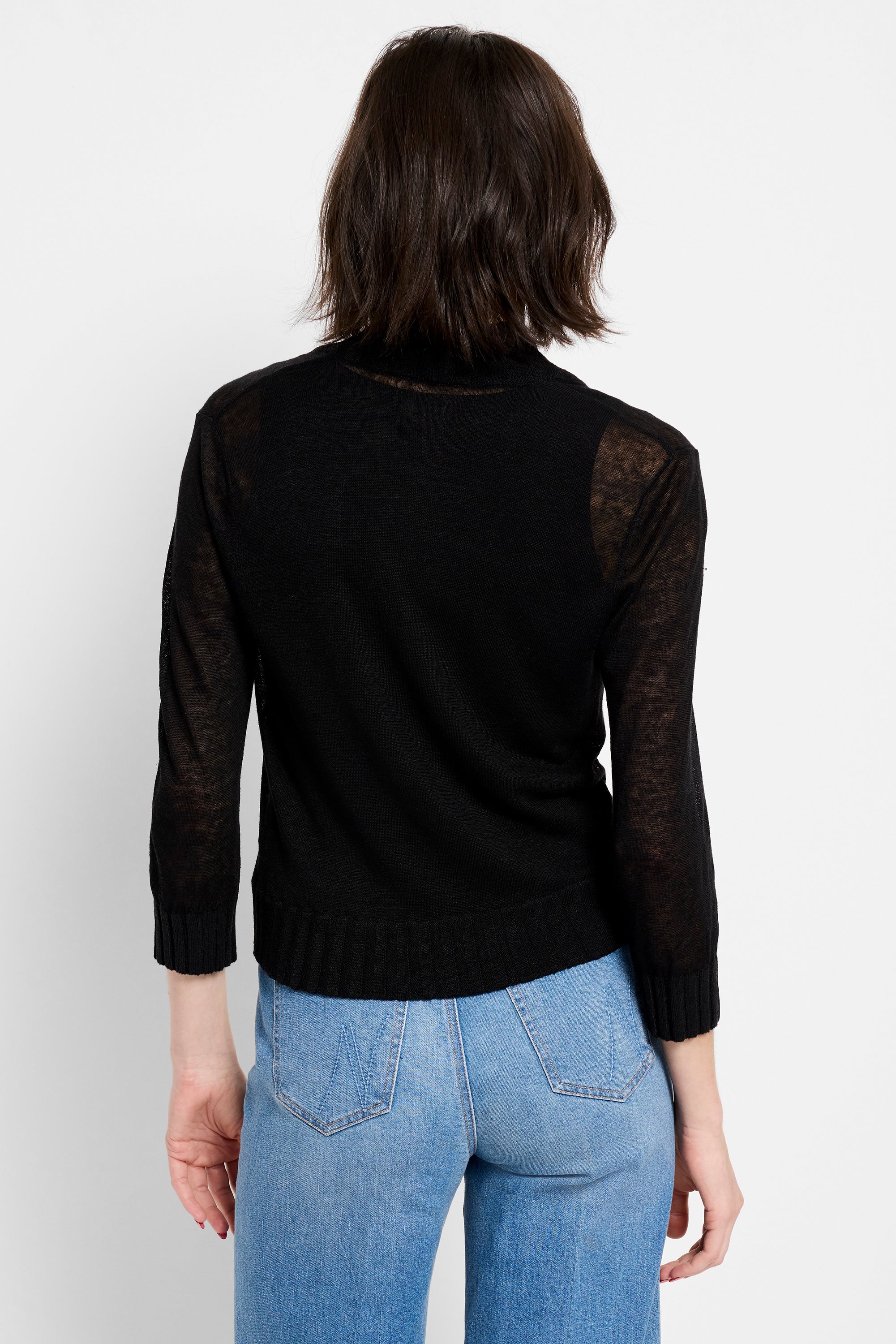 Black fitted sheer knit sweater features a high neck and 3/4 sleeves, paired with light wash jeans.