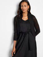 Black cropped bolero cardigan with 3/4 sheer knit sleeves and ribbed open front.