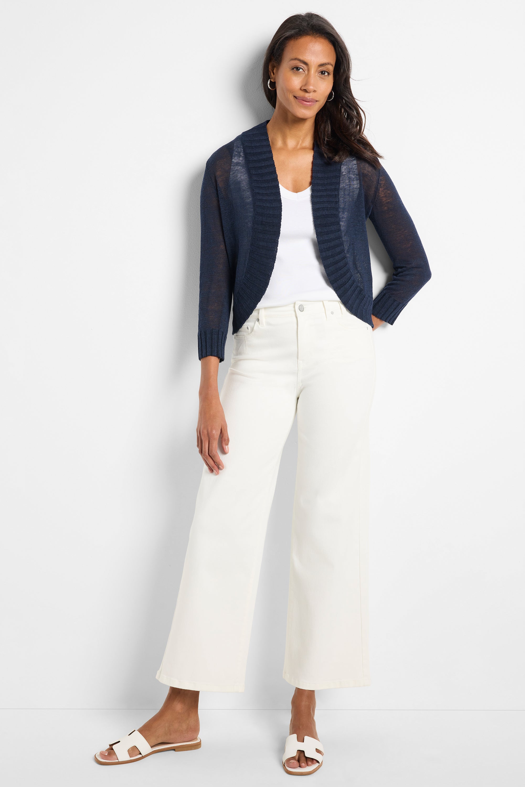 Model wears a navy cropped cardigan with sheer fine knit and wide ribbed collar detail.