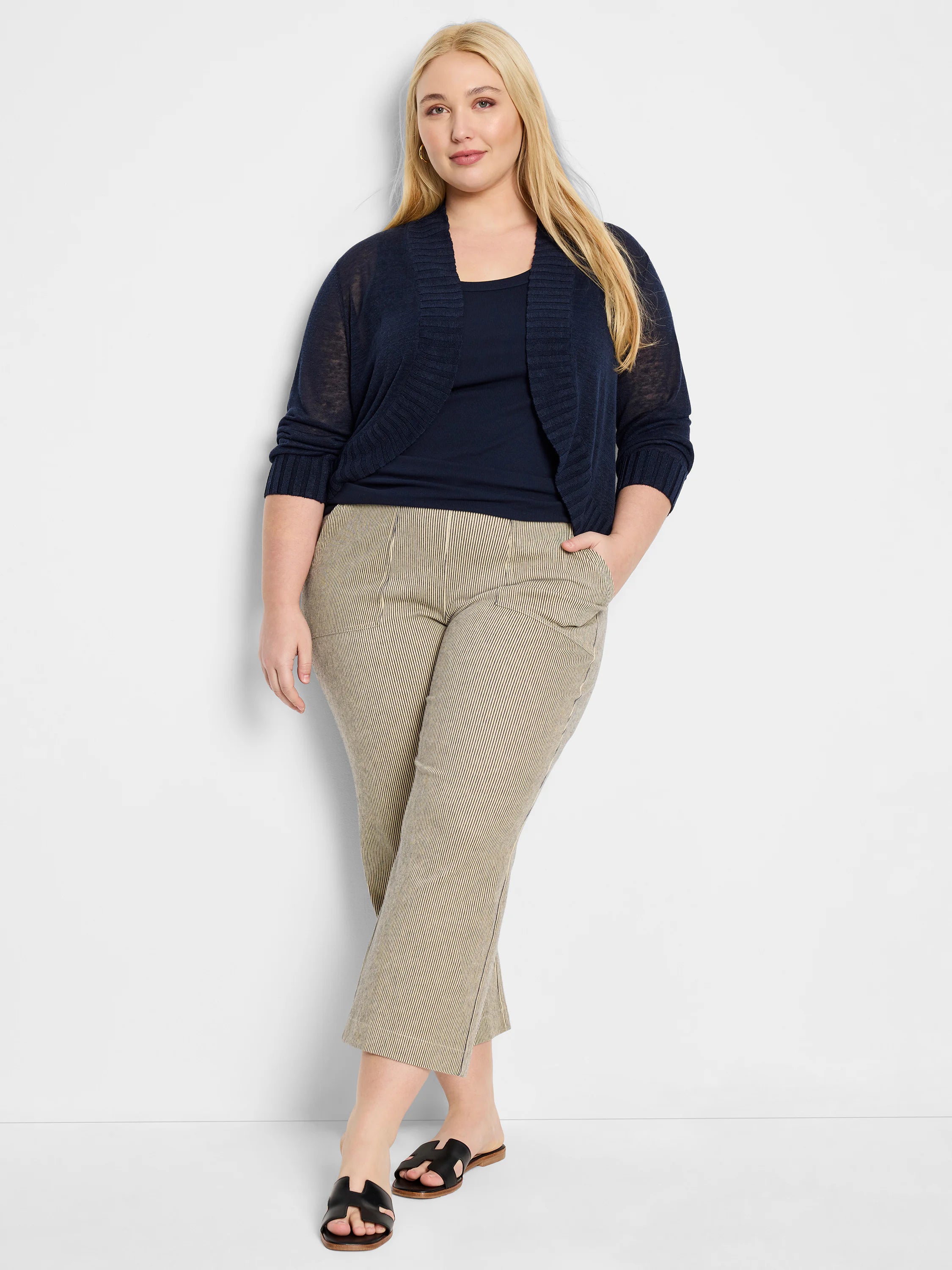 Navy bolero cardigan with sheer knit body, 3/4 sleeves, and ribbed cuffs/front trim. Open front.