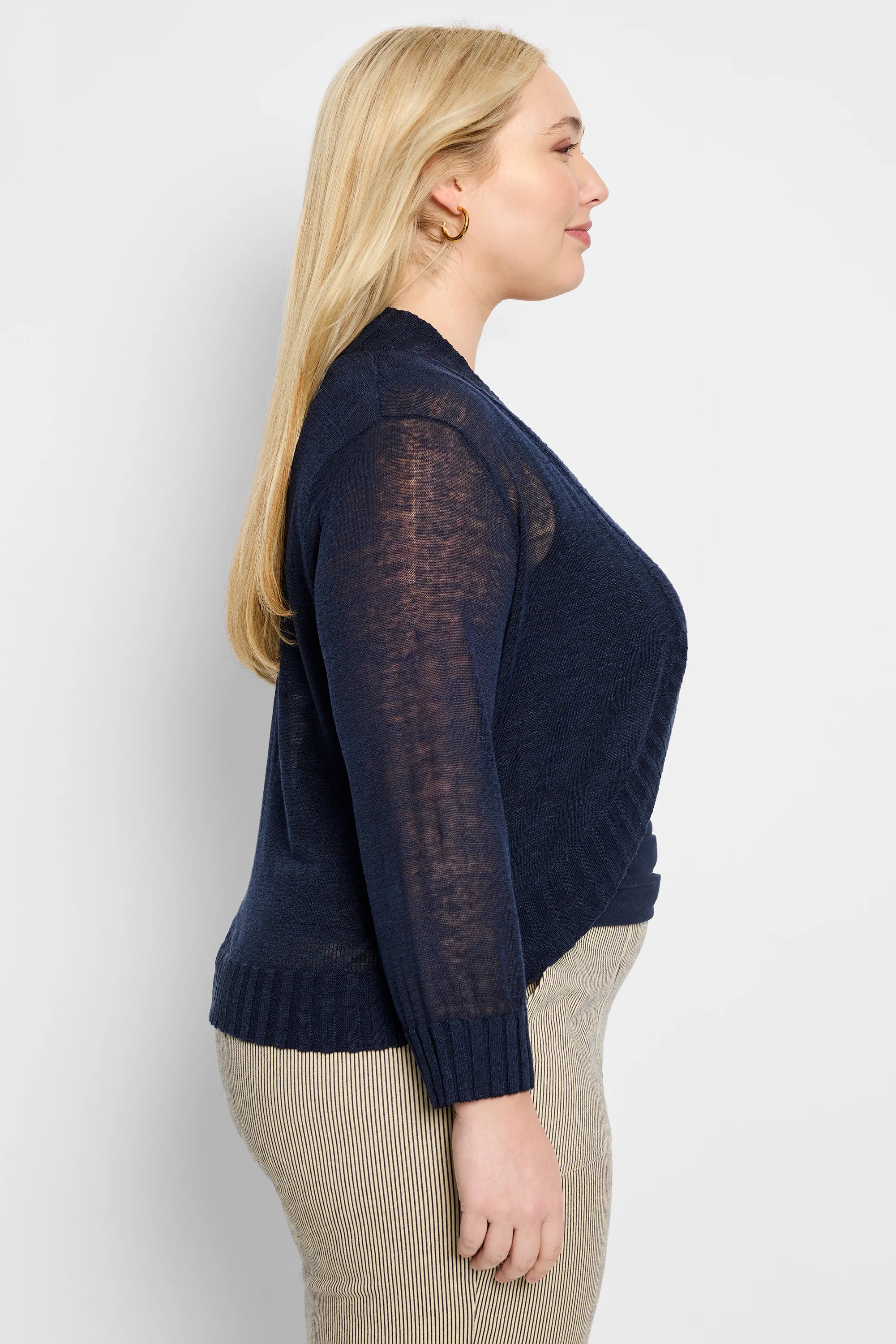 Navy blue sheer knit bolero cardigan with an open front, long sleeves, and ribbed cuffs and hem.