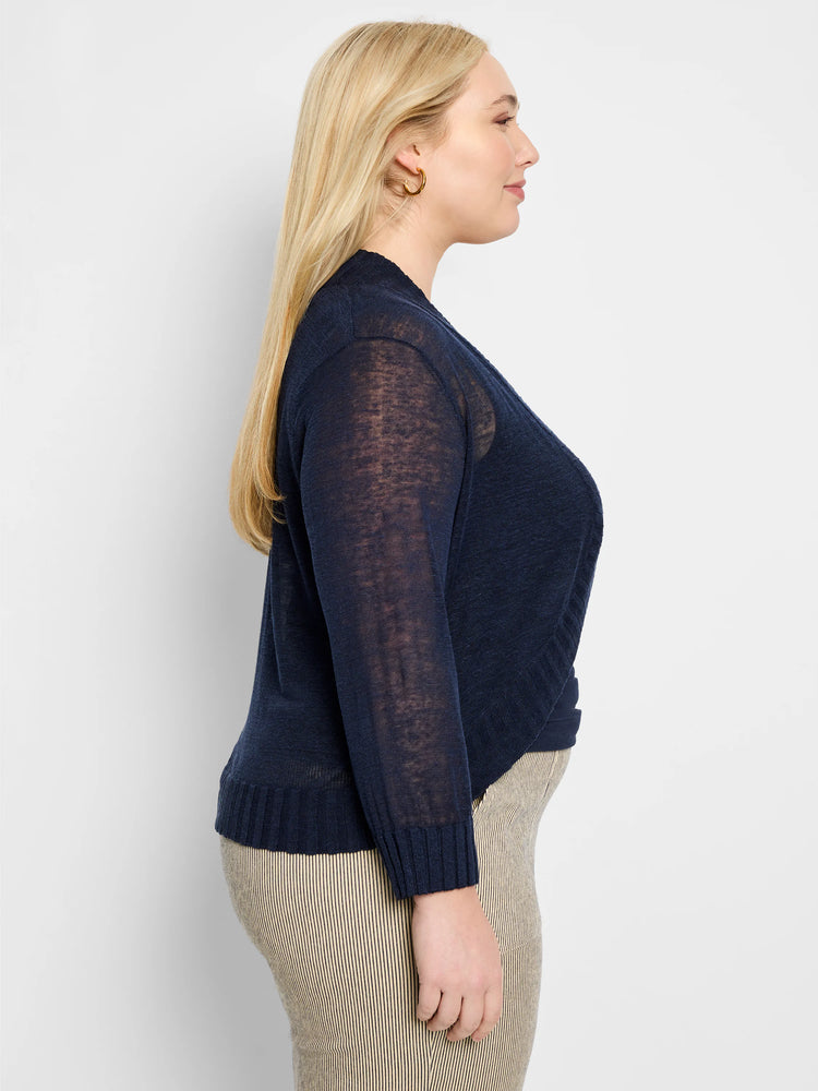 Navy blue sheer knit bolero cardigan with an open front, long sleeves, and ribbed cuffs and hem.