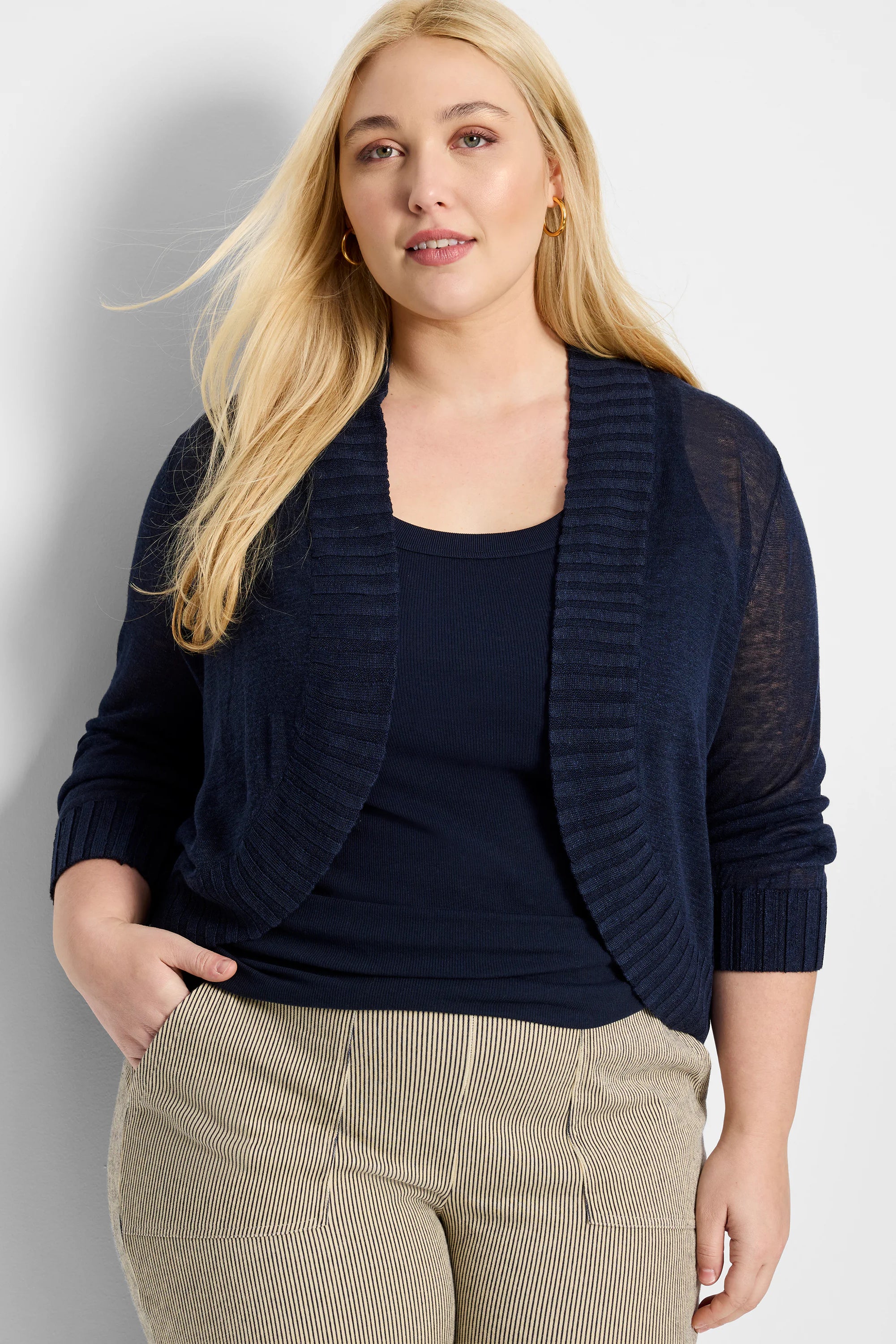 Navy blue bolero cardigan, cropped, open-front with ribbed collar & cuffs, and three-quarter sheer sleeves.