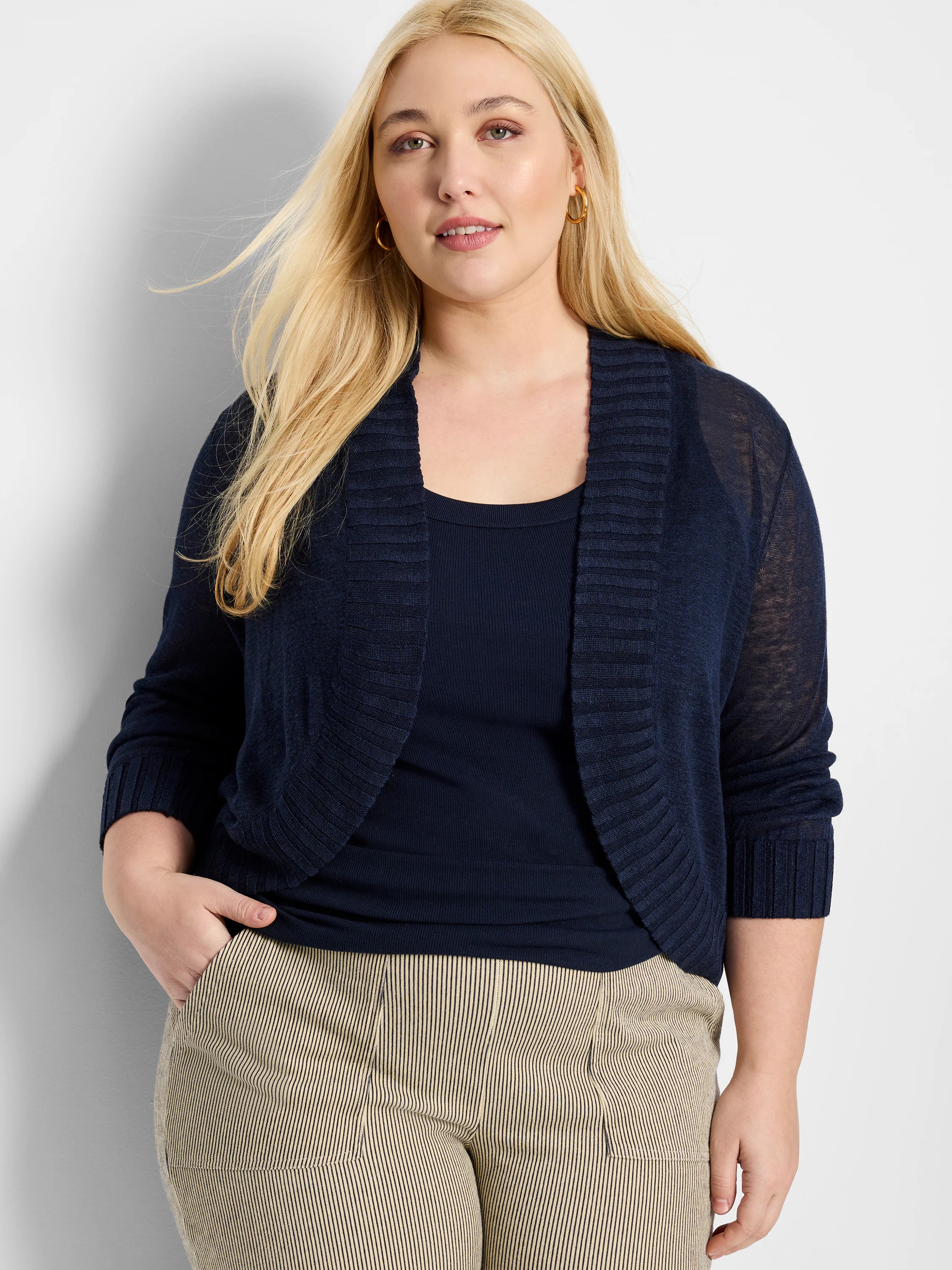Navy blue bolero cardigan, cropped, open-front with ribbed collar & cuffs, and three-quarter sheer sleeves.