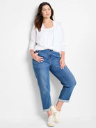 White open-front long-sleeve cardigan with a twisted front hem, worn over a white tank top.