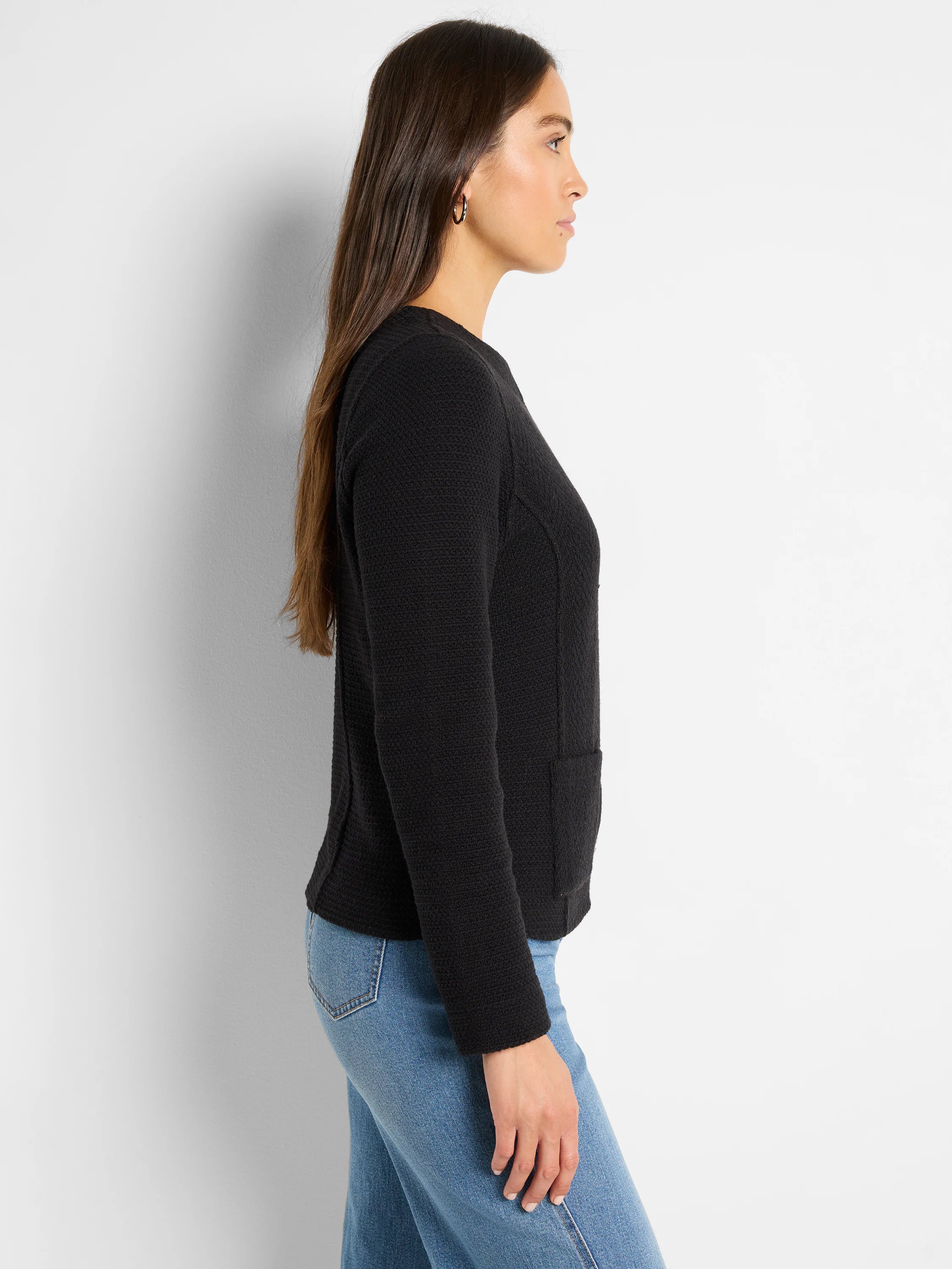 Black weave mix knit jacket with long sleeves and patch pockets, shown on a model from the side.