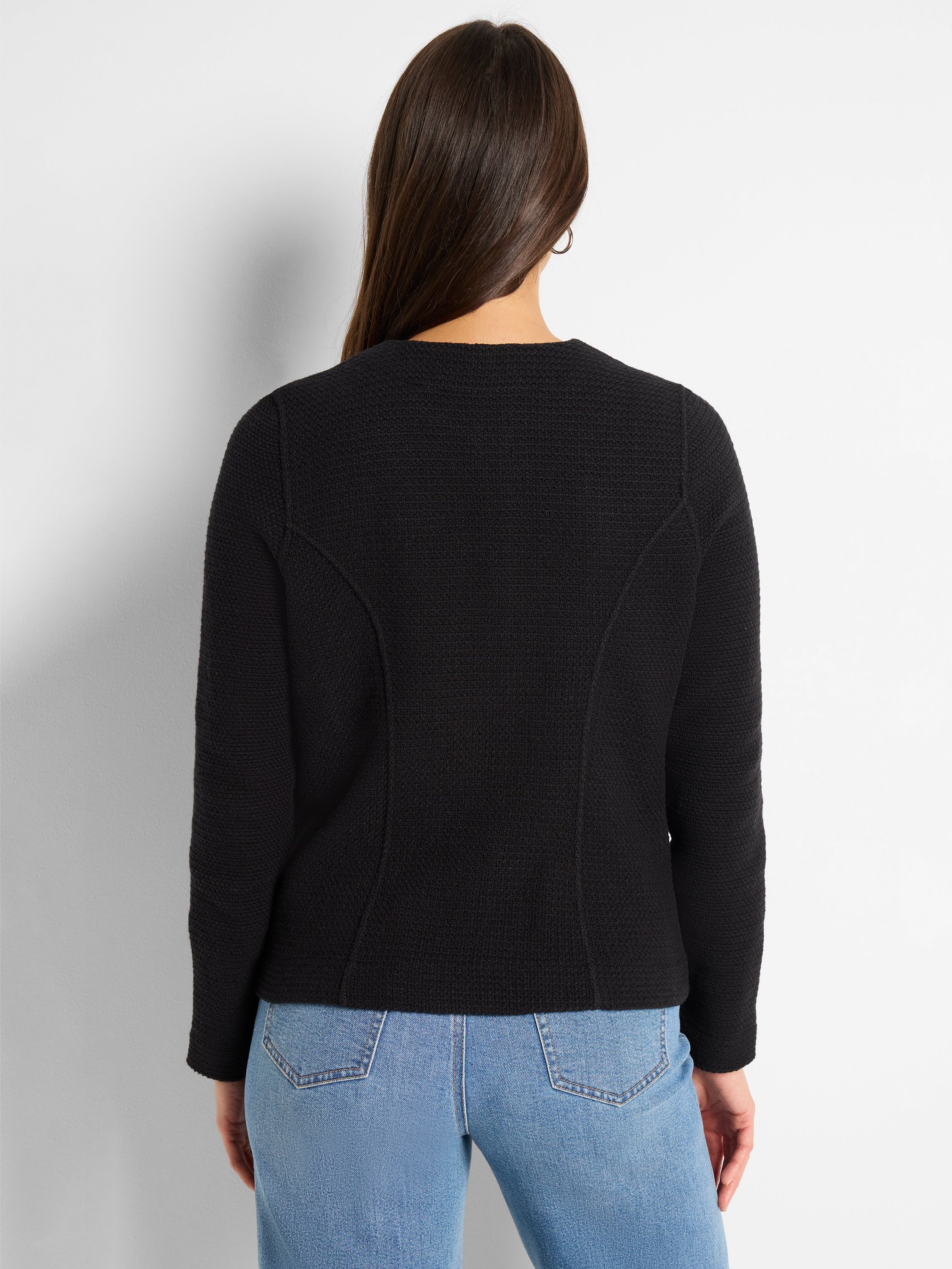 A fitted black textured knit jacket features subtle shaping seams visible on the back.