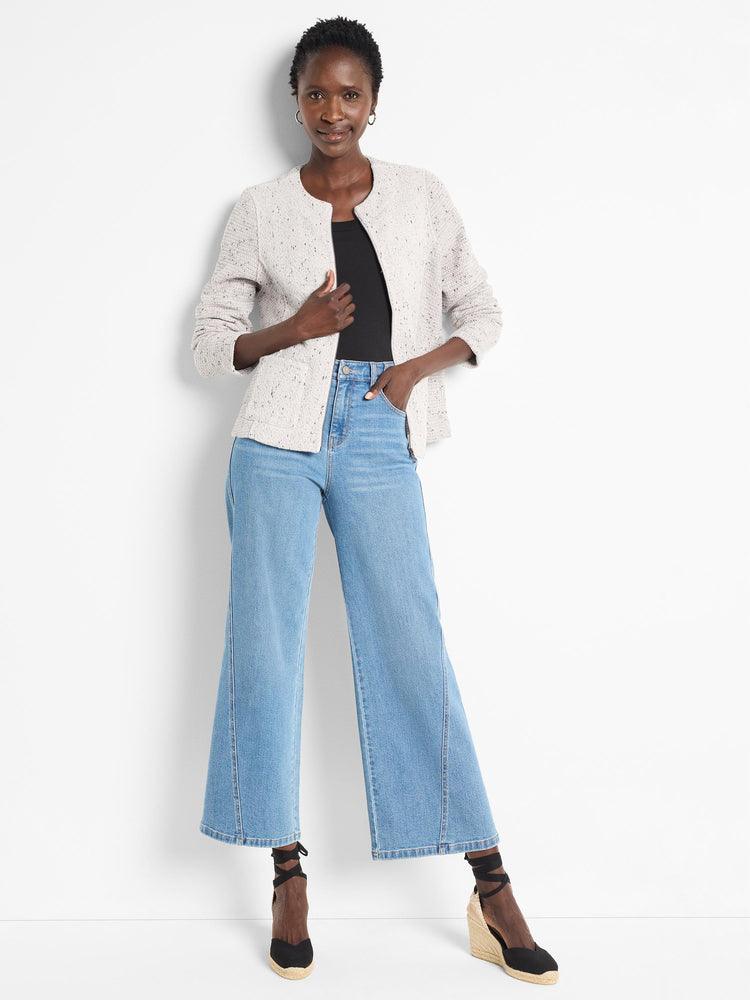 A collarless textured cream jacket is paired with light wash wide-leg denim jeans and espadrille wedges.