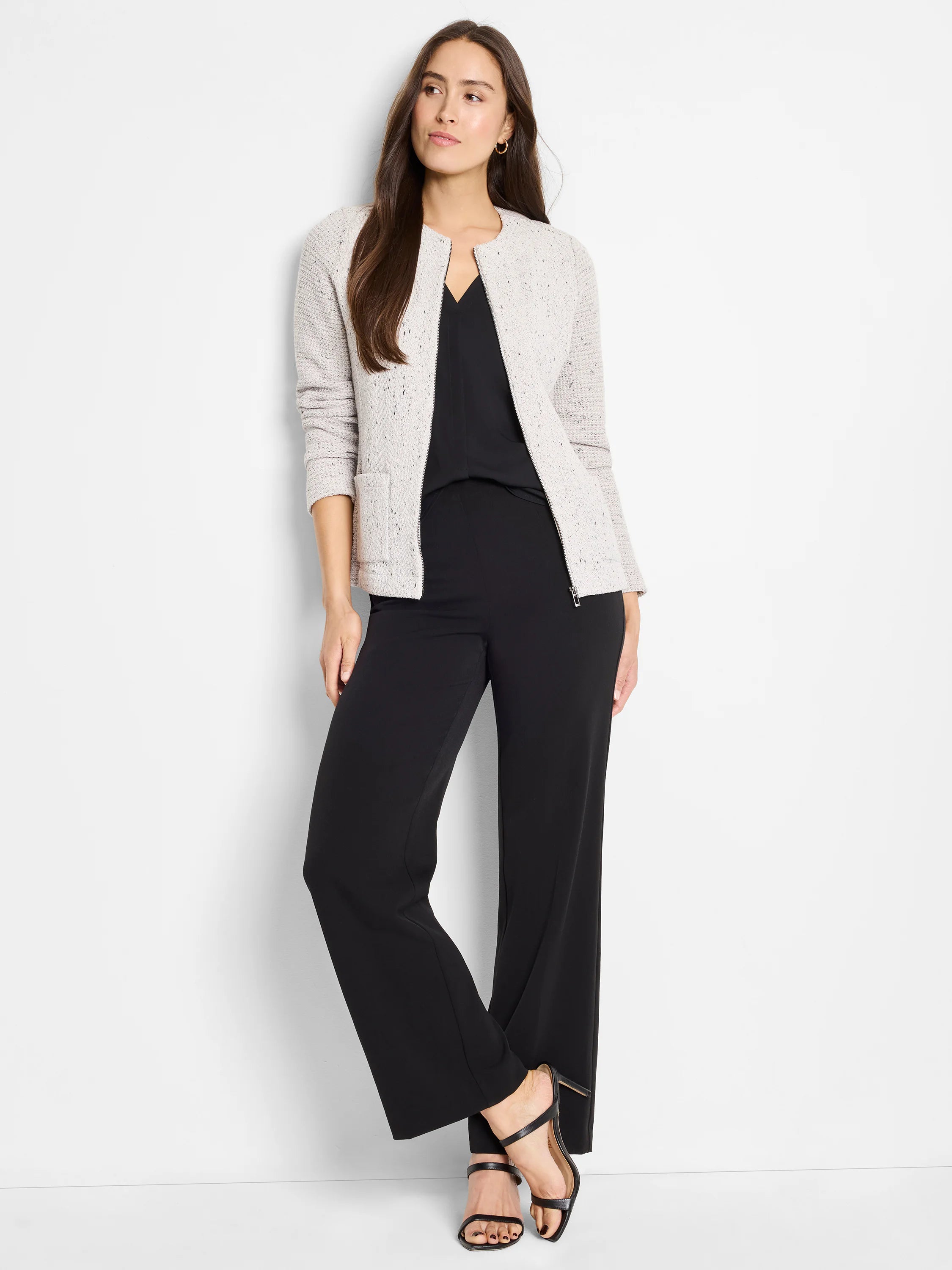 Light grey textured jacket with round collarless neckline, front zipper, and patch pockets, over black top and pants.