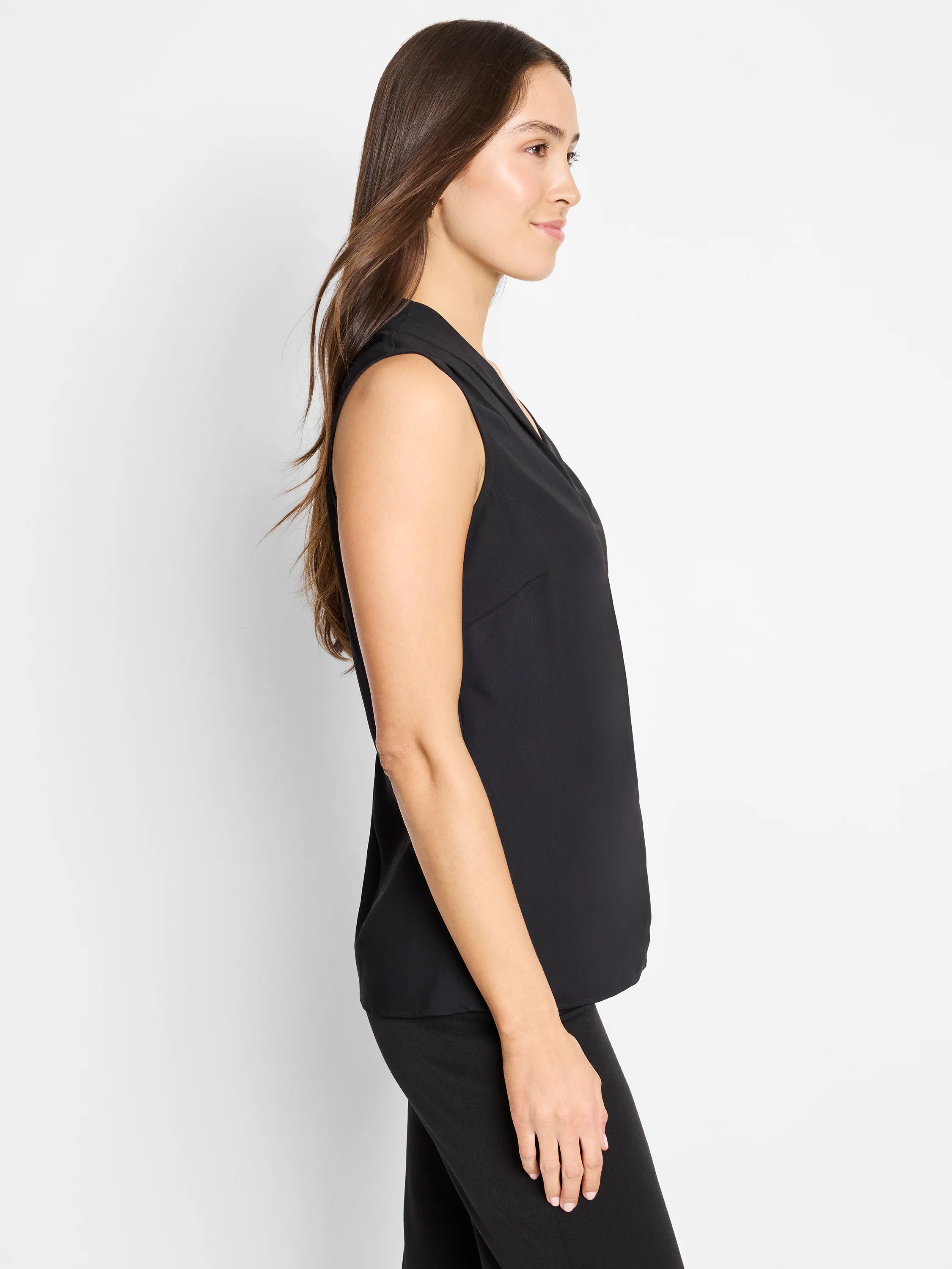 Black sleeveless V-neck top with a soft, draped collar, worn by a woman facing right.