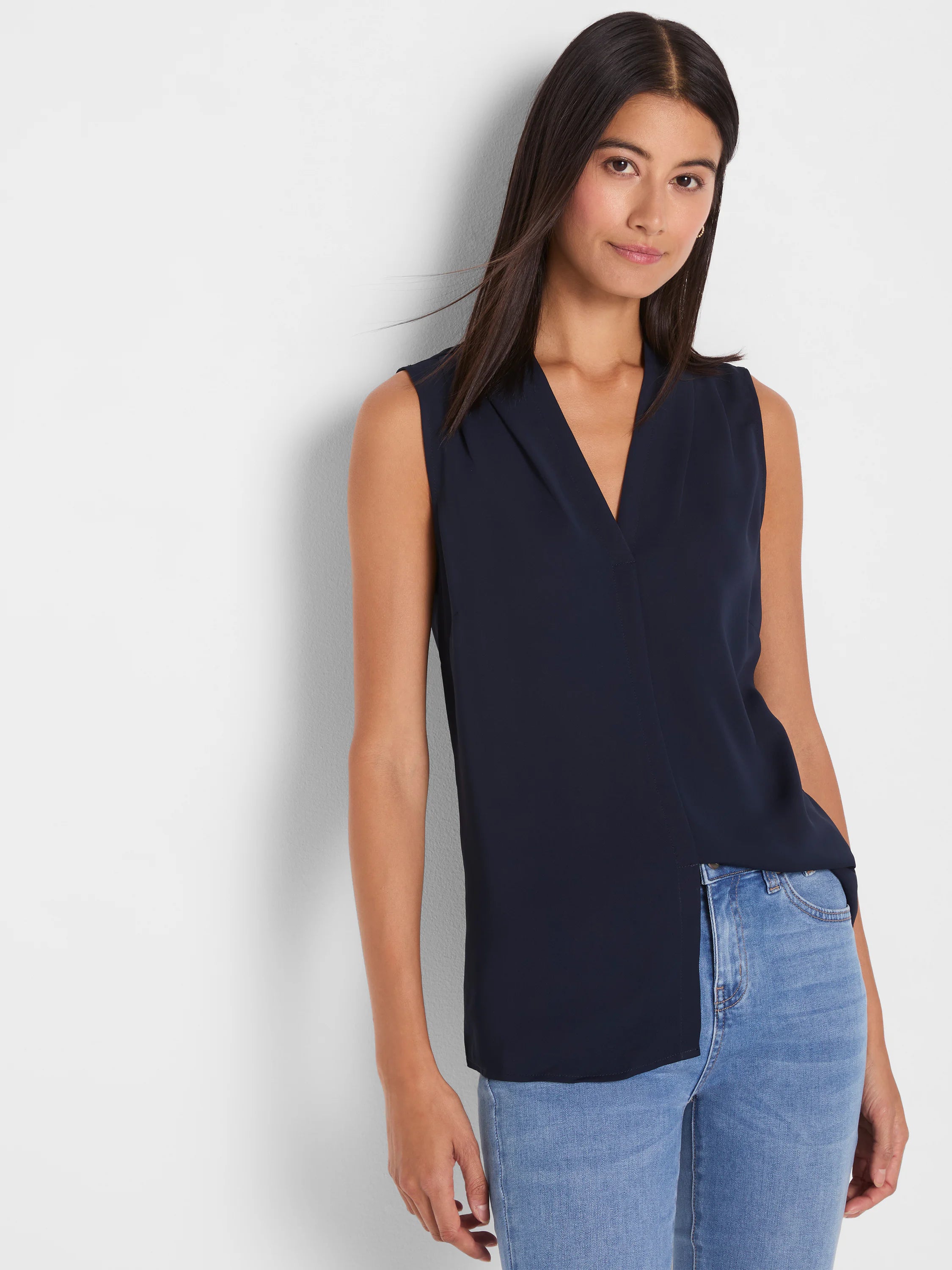 Navy blue sleeveless V-neck top with crossover front and asymmetrical hem.