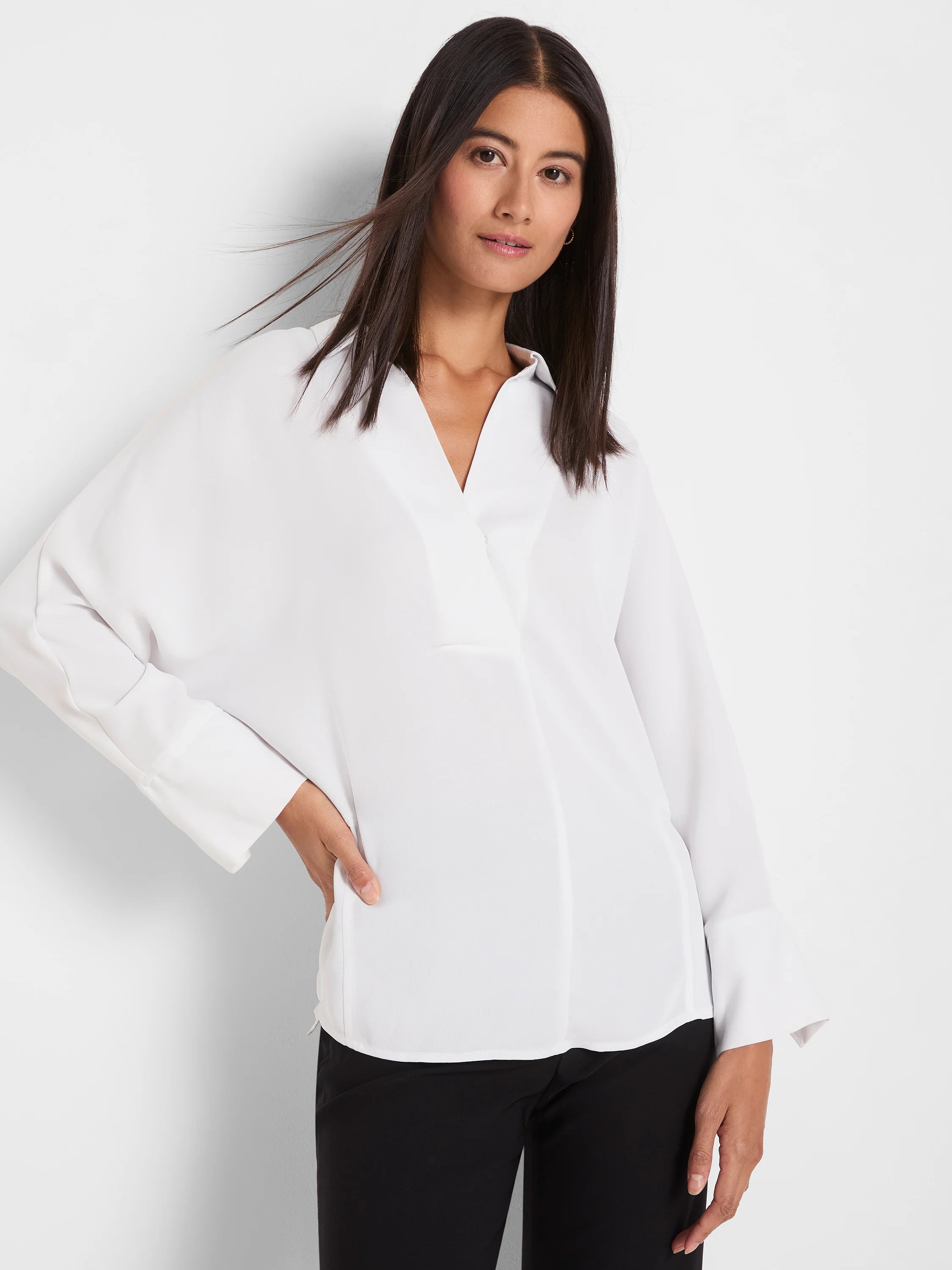 White, relaxed-fit blouse with crossover V-neck and wide cuffed long sleeves.