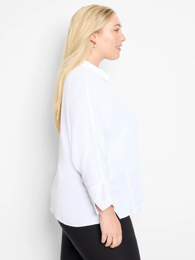 White collared blouse, relaxed fit, long sleeves with folded cuffs. Model shown in profile.